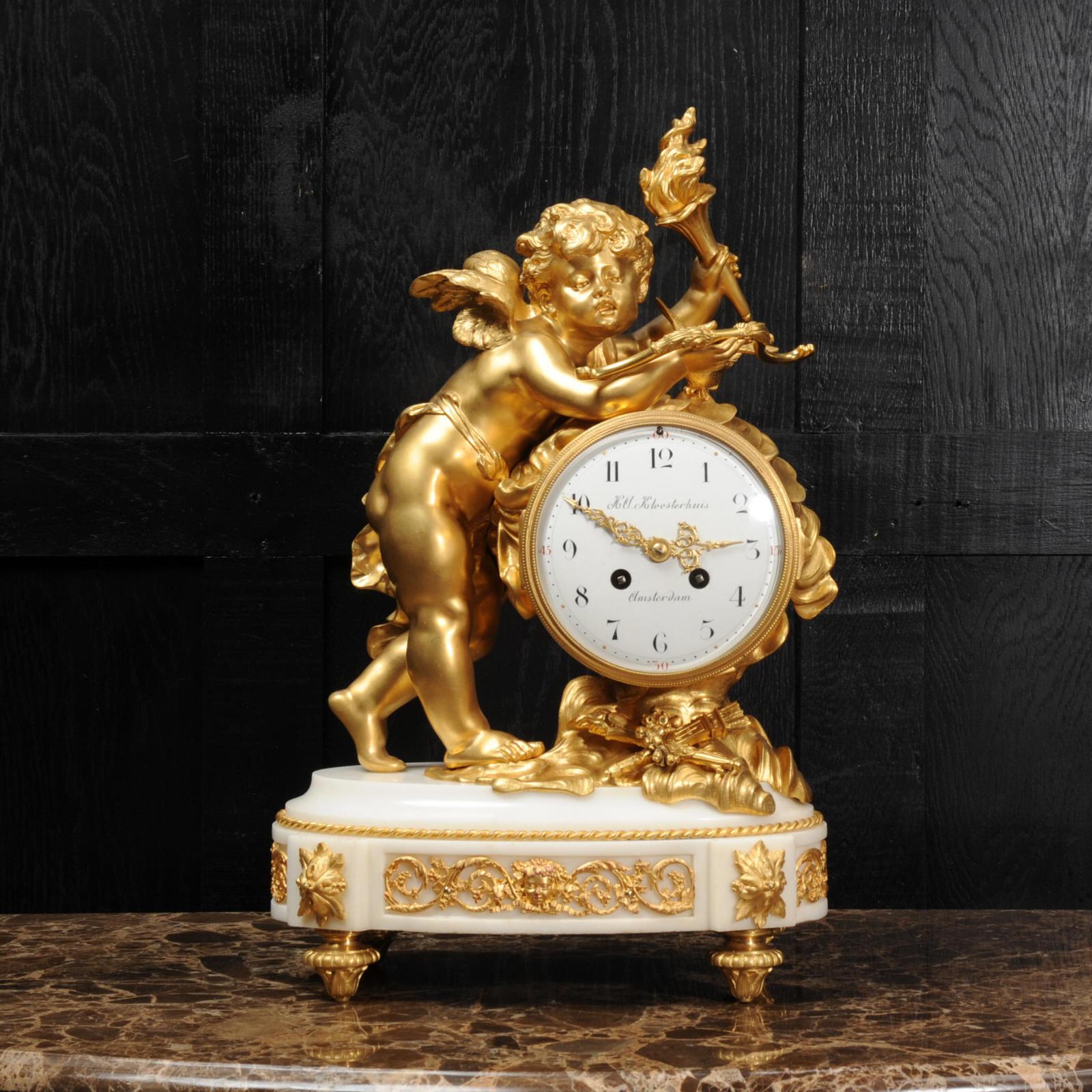 A large and stunning original antique French clock of the highest quality. It depicts Cupid among the clouds, carrying a flaming torch with which to enflame his victims with love and a bow from which he has fired an arrow. Between his arms is a