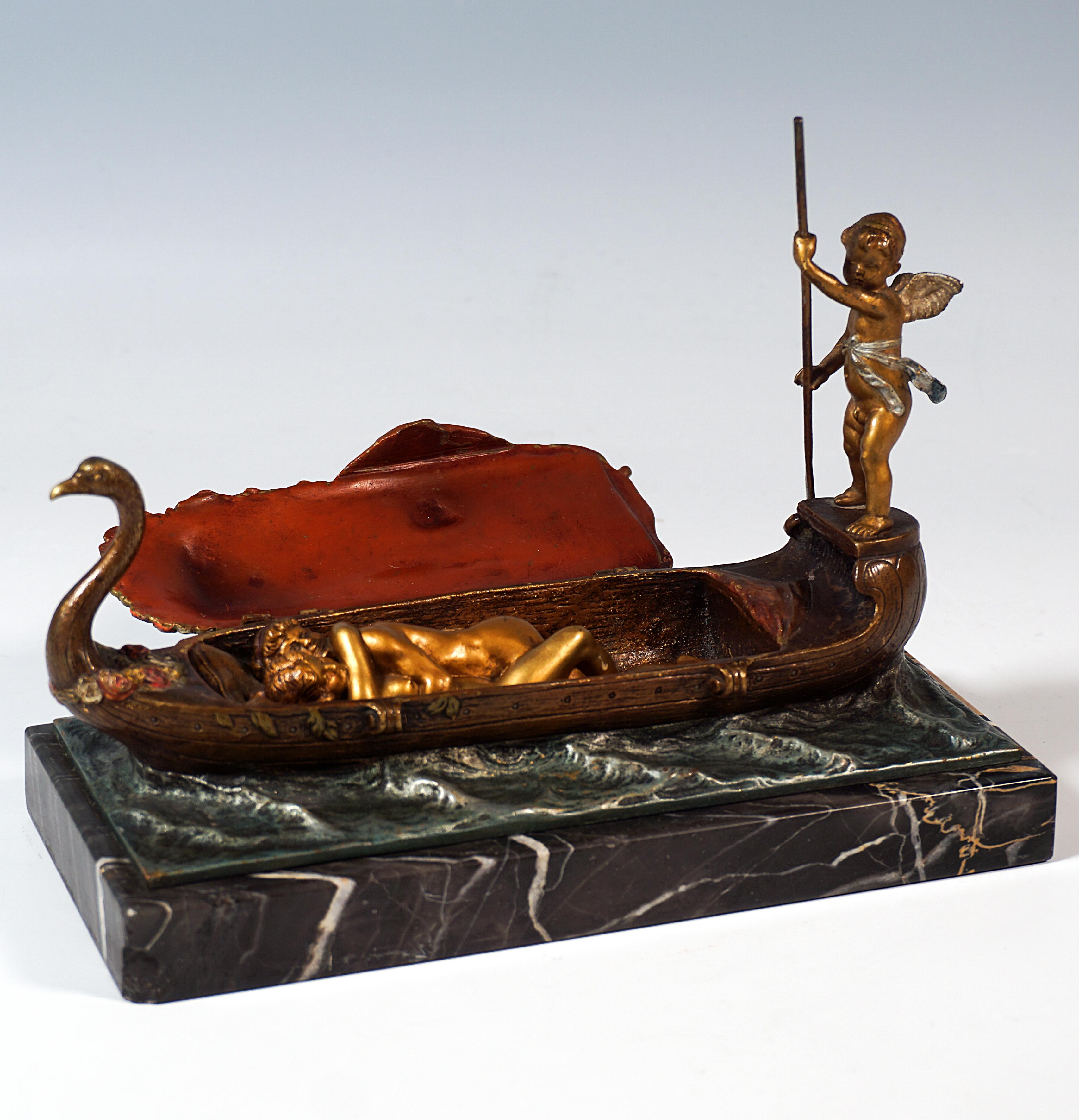A narrow, long bronze gondola with a swan-neck bow at the front and a rounded stern with a platform on which a winged cupid steers the rudder. In front of him on the boat is a bed of flowers, half covered by a large cloth, on which lie the remaining