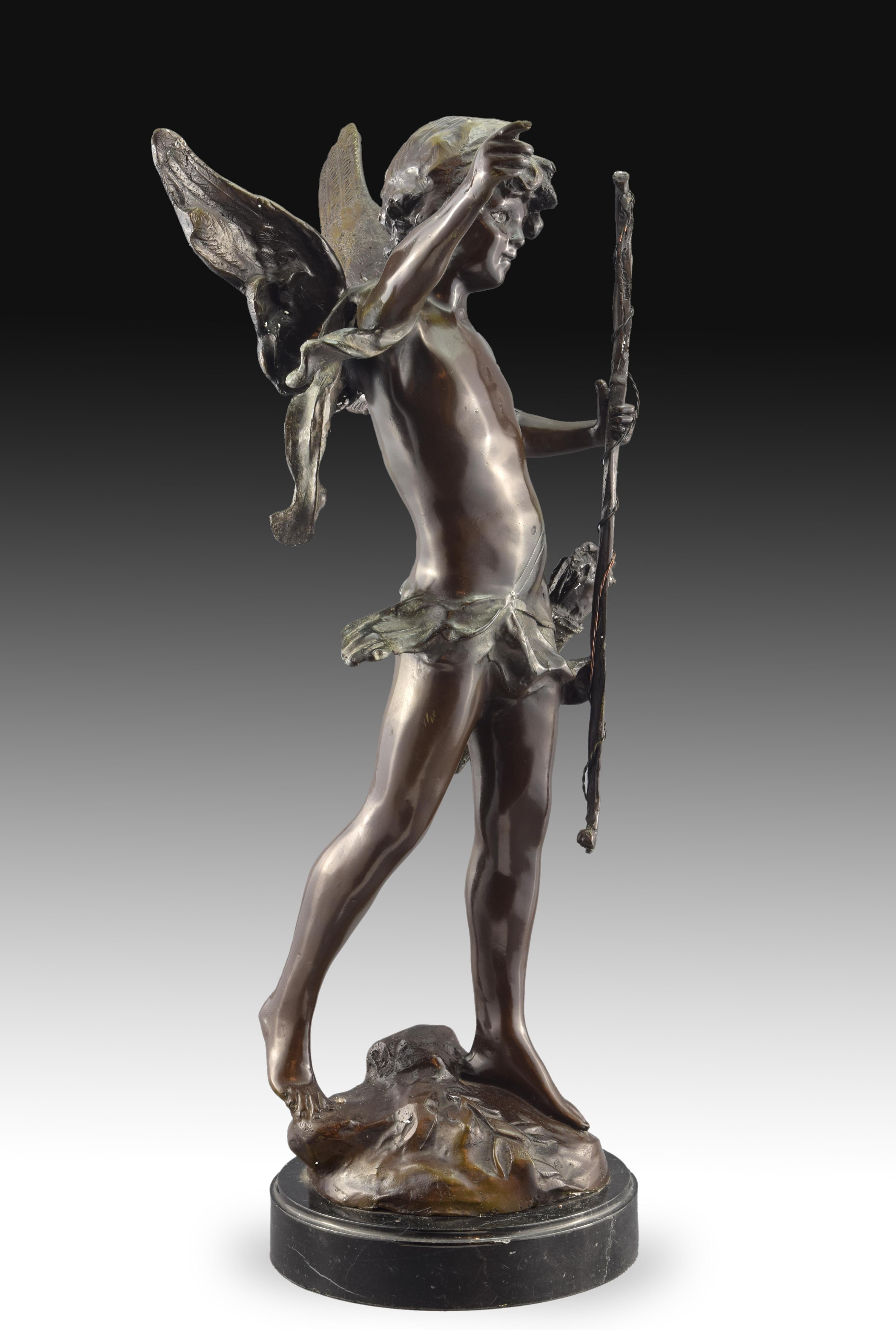 Sur une base ronde se dresse la figure du dieu de l'amour, Cupidon. La sculpture en bronze, avec les attributs iconographiques correspondant à cette figure de la mythologie classique, a été réalisée d'après les modèles d'August Moreau (1834-1917).