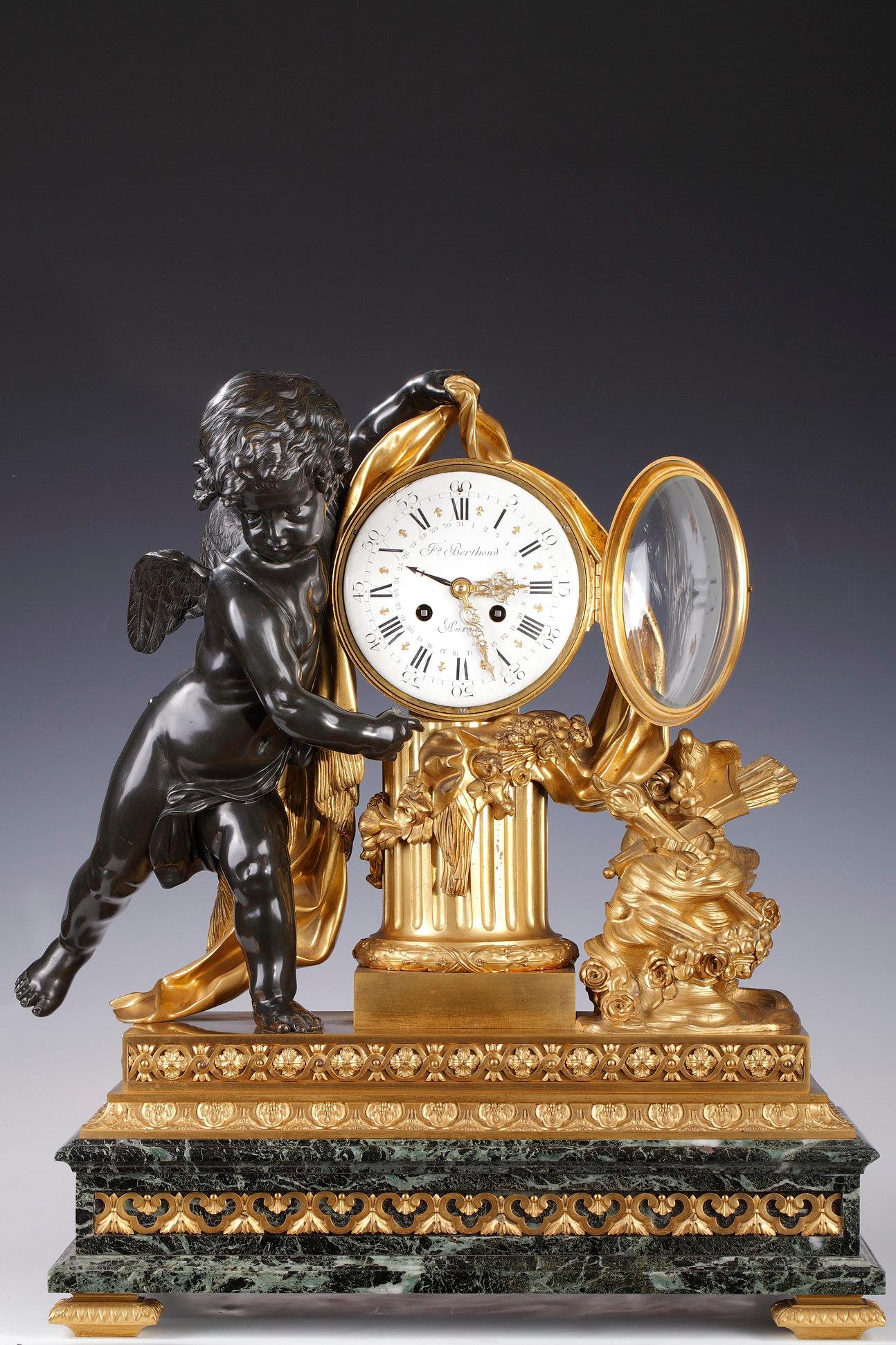 Signed on the dial F. Berthoud Paris.
Important gilded and patinated clock representing Cupid holding a drape which discovers a dial placed on a truncated fluted column. He points out his attributes, a torch and a quiver, supported by a flowery