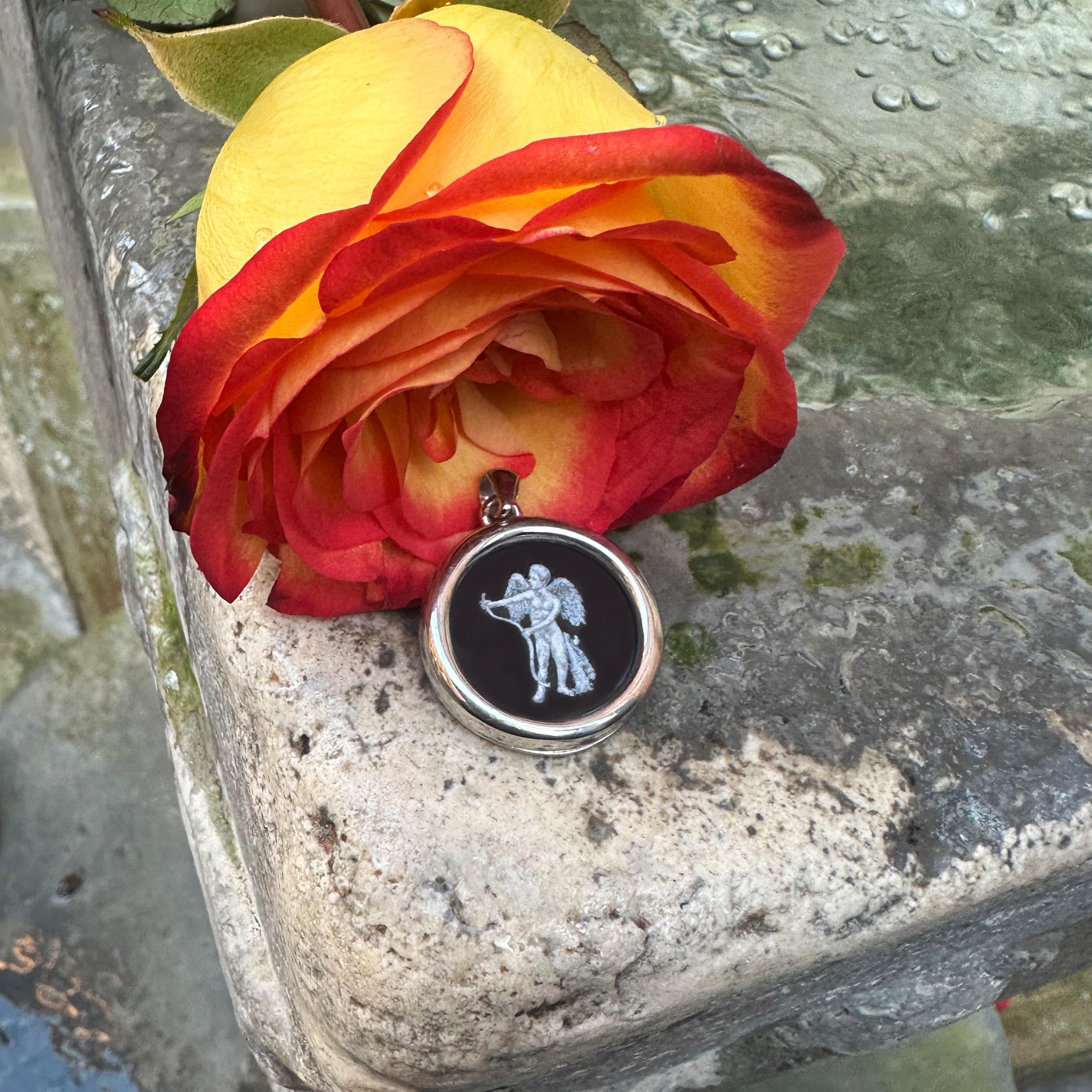 Questo ciondolo presenta una raffigurazione dipinta a mano della figura mitica di Cupido, magistralmente realizzata dall'artista Tommaso Rossi su Onice. Incastonato in argento massiccio, celebra Cupido, l'emblema dell'amore e del desiderio, spesso