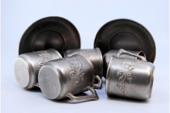 Cups and saucers in embossed silver with floral motifs