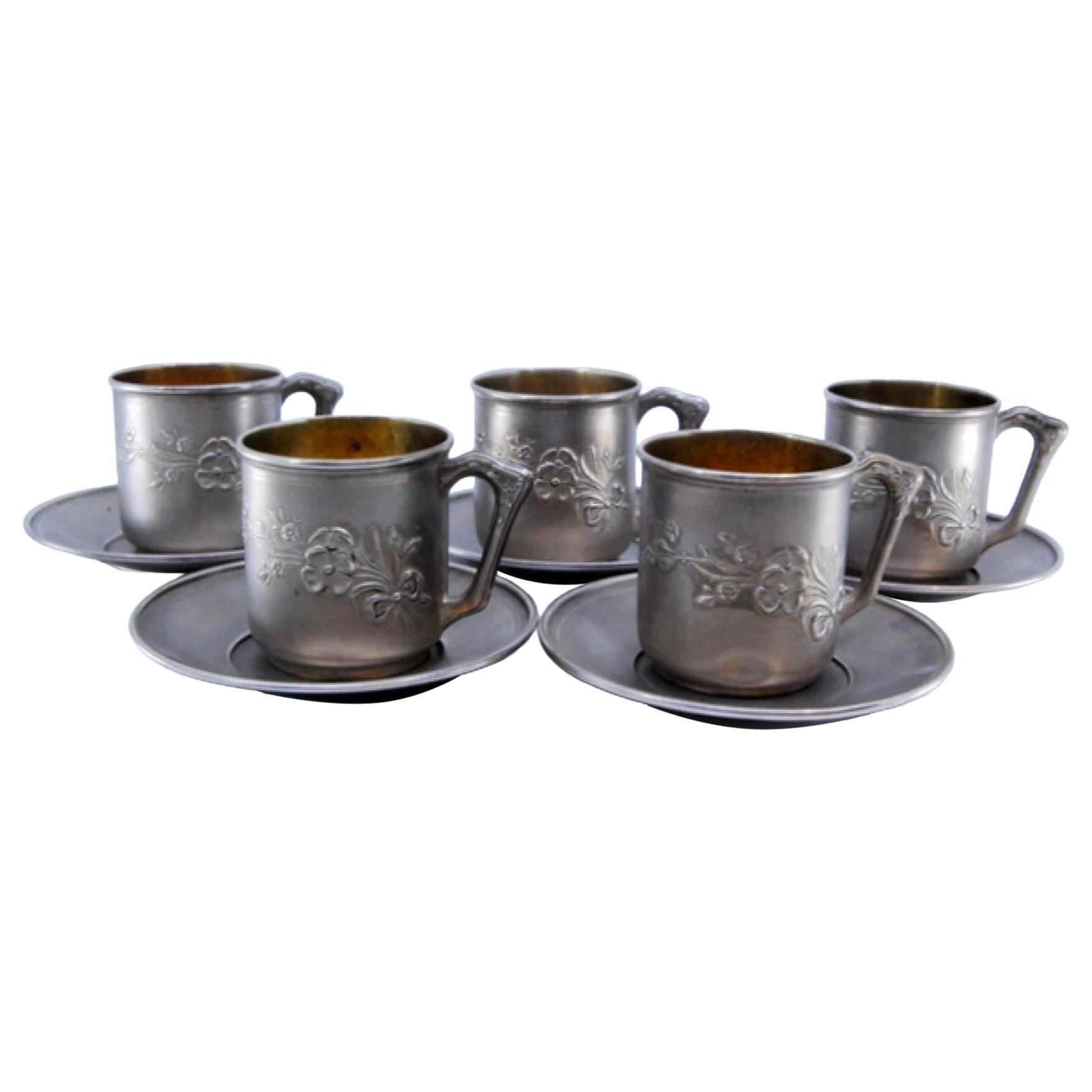 Cups and saucers in embossed silver with floral motifs