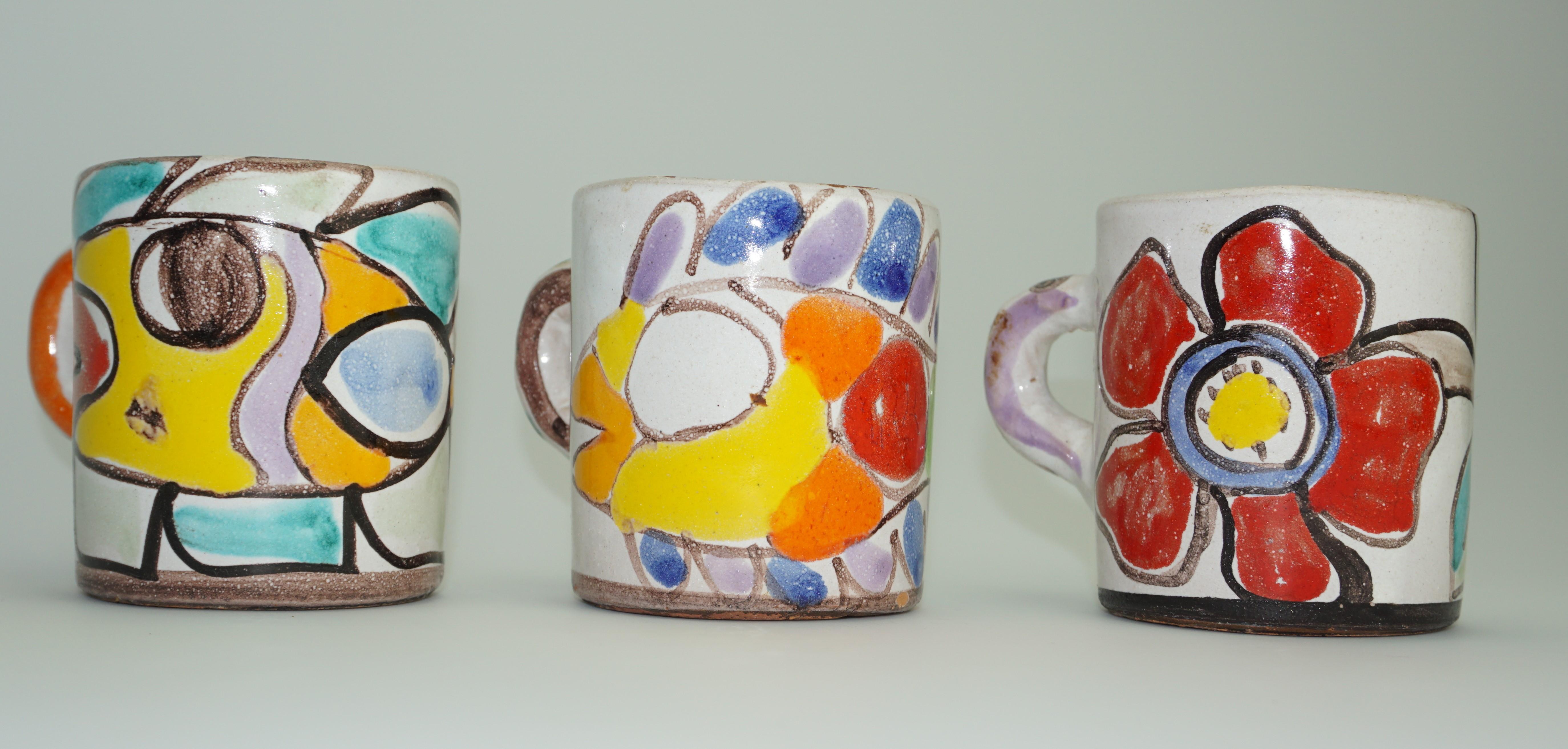 Decorative expresso cups by Giovanni DeSimone, Italy, C 1960. Three beautiful ceramic cups. One cup has a floral motif, the other two cups have decorative fish motif. Good condition.