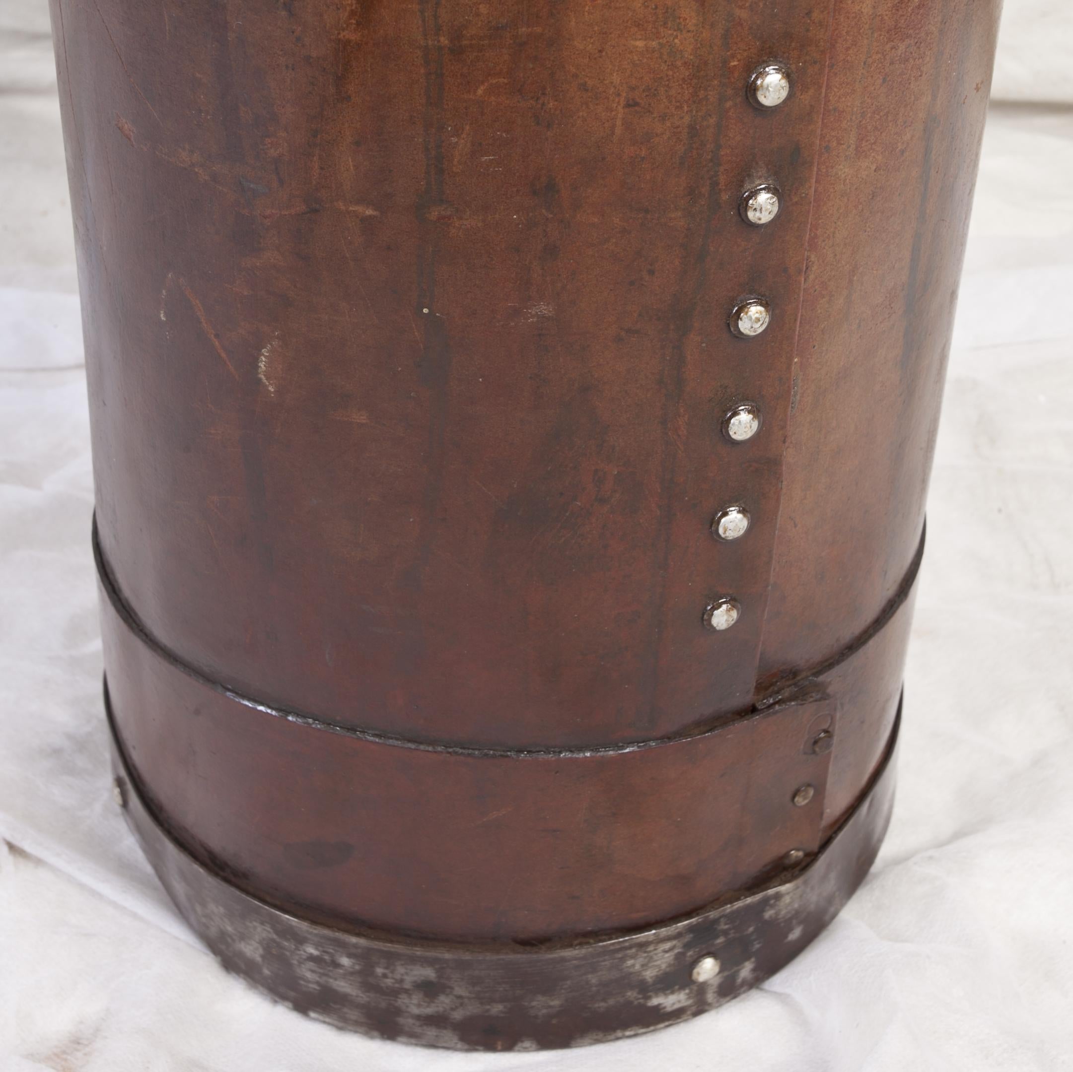 Cured leather umbrella stand with metal base and top rim, and metal rivets down the side. European. As of this writing I have three of these and priced individually, circa 1940s. Could also use for tall plant arrangements.