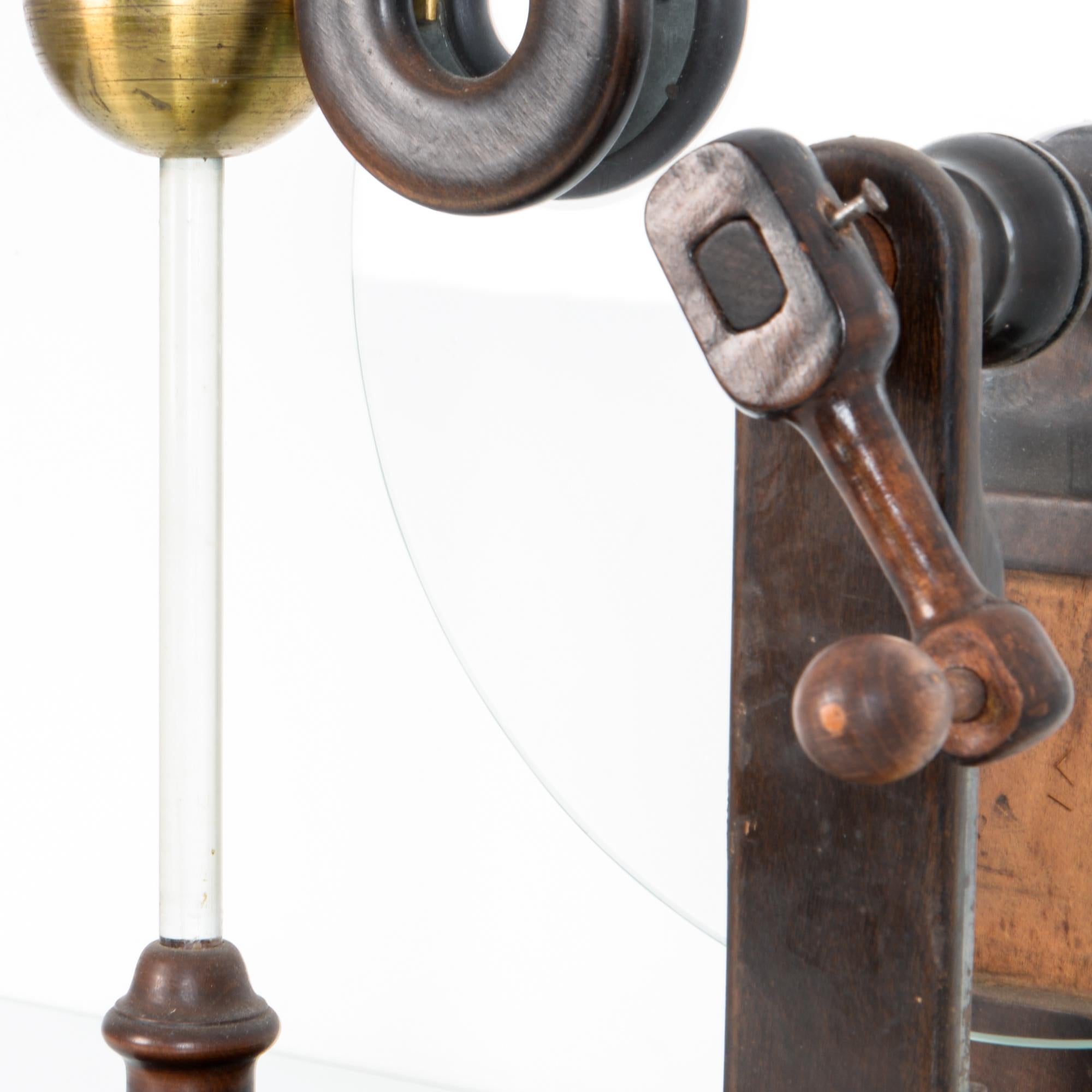 A tabletop wood, brass, and glass apparatus, this didactic instrument was used to demonstrate the production of static electricity. A beautiful design object, shows the attention to detail taken in constructing scientific instruments, in typical