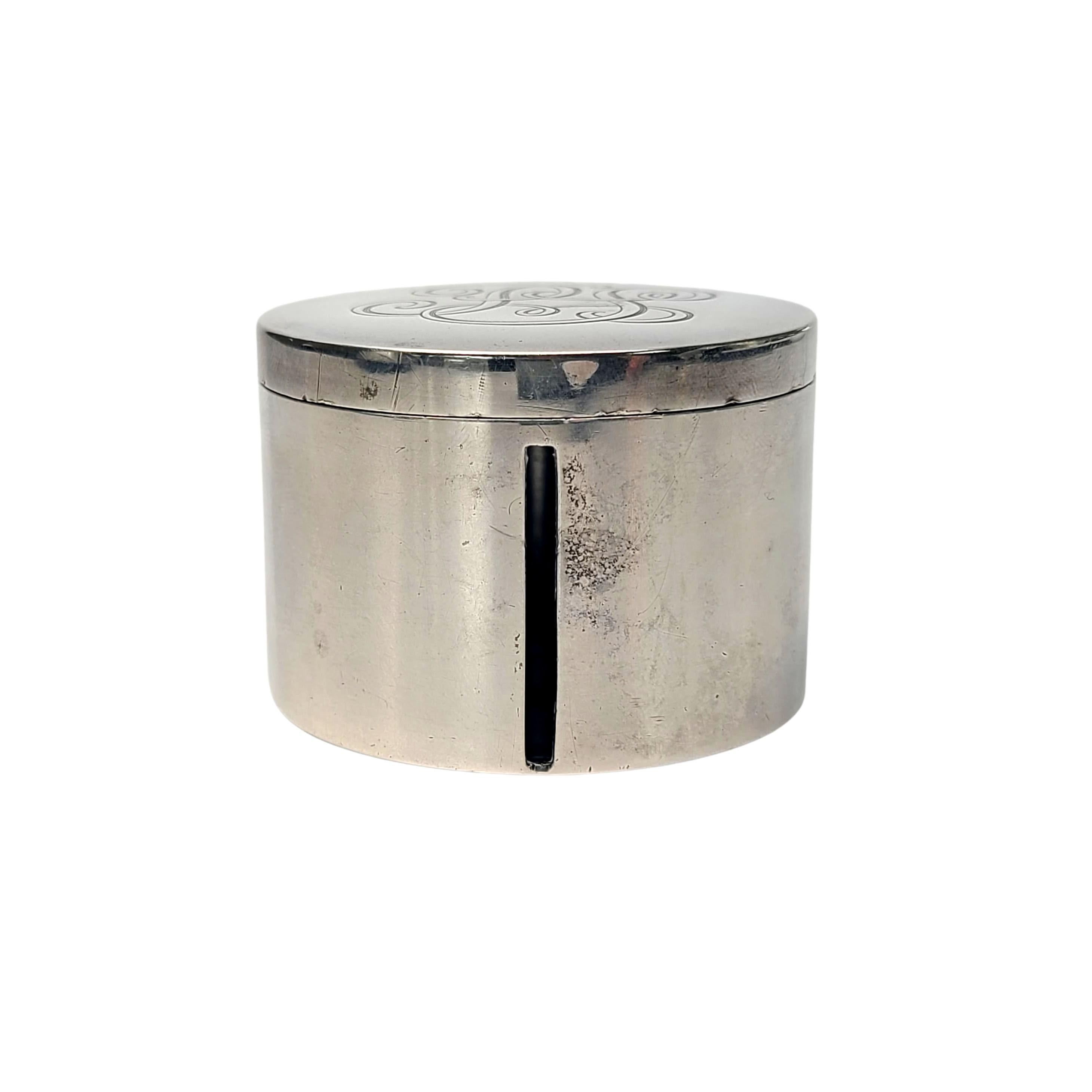 Sterling silver round box for postage stamps by Currier & Roby.

Monogram appears to be PS

A small round box with a lid, stamps can be dispensed from a roll thru the vertical slot in the side of the box. Currier & Roby was active from 1900 thru