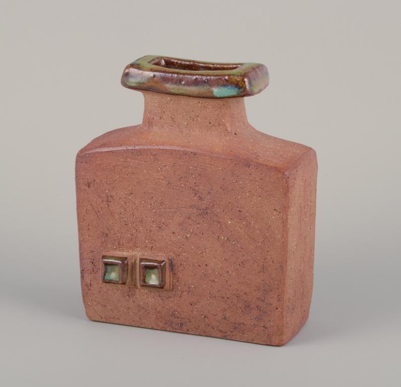 Curt Magnus Addin (1931-2007), ceramista svedese. Studio proprio.
Vaso unico in ceramica in stile modernista. Argilla Chamotte.
1970s.
Marcato e firmato.
In perfette condizioni.
Dimensioni: L 14,0 cm x P 7,0 cm x H 17,0 cm.
