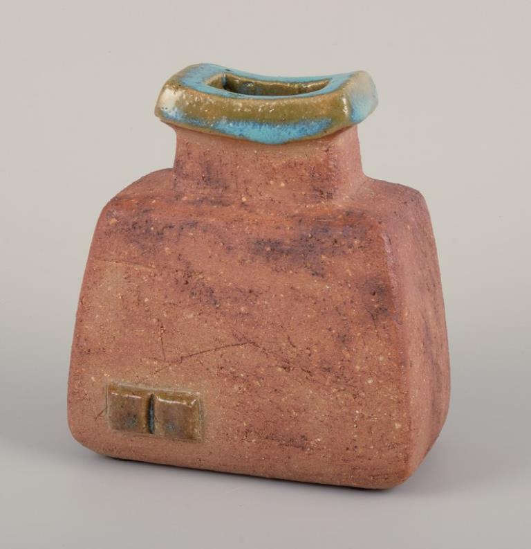 Curt Magnus Addin (1931-2007), ceramista svedese. Studio proprio.
Vaso unico in ceramica in stile modernista. Argilla Chamotte.
1970s.
Timbrato e firmato.
In perfette condizioni.
Dimensioni: L 13,0 cm x P 8,0 cm x H 14,0 cm.