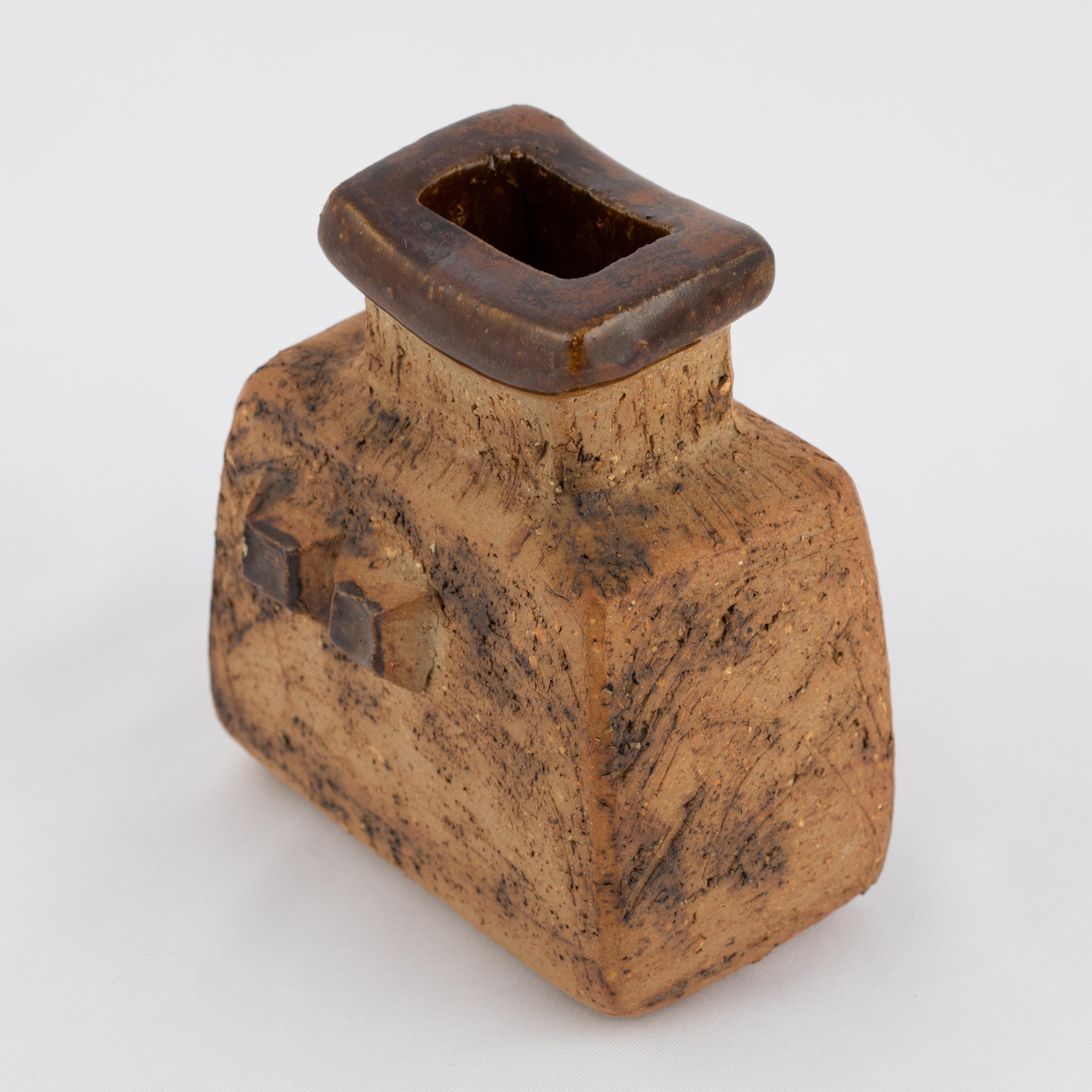 Stoneware vase with brown-glaze accents by Swedish artist Curt Magnus Addin (1931-2007). The rectilinear Brutalist form features a rough stoneware surface and a raised pattern of two glazed squares on front and back. The opening is highlighted with