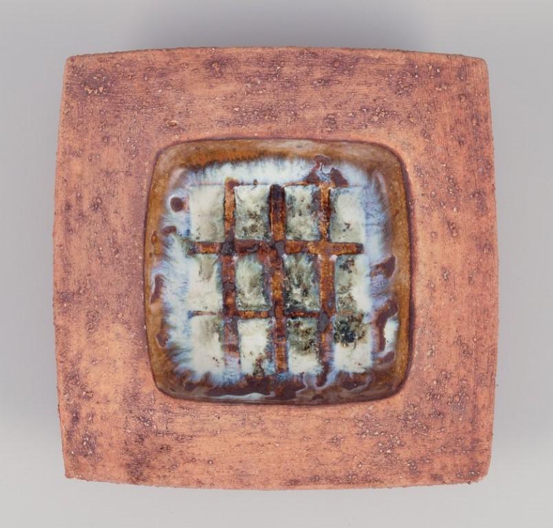 Curt Magnus Addin, own workshop, Swedish ceramic artist.
Large square bowl with an abstract design.
From the 1970s.
Marked and signed.
In excellent condition with a minor chip on the lower part of the rim.
Dimensions: Diameter 25.0 cm x Height 5.0