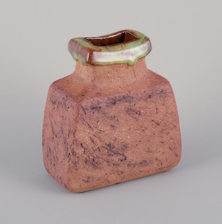 Curt Magnus Addin, own workshop, Swedish ceramic artist.
Unique ceramic vase in a modernist style, made from chamotte clay.
From the 1970s.
Marked and signed.
In perfect condition.
Dimensions: Width 13.0 cm x Depth 8.0 cm x Height 14.5 cm.