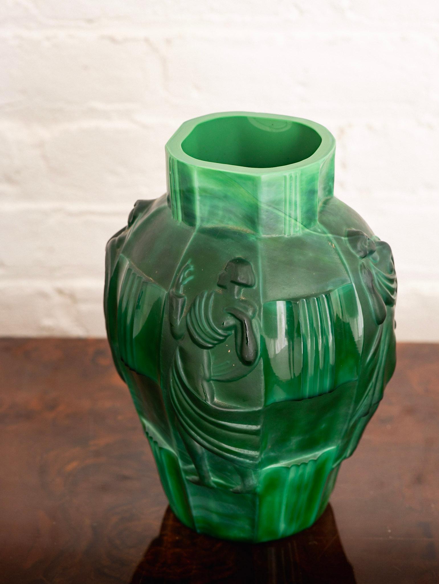 Art Deco jade glass vase by Curt Schlevogt(1869-1959) for Ingrid. 
Schlevogt was an American-born, Czech glass designer and entrepreneur. Schlevogt is best known for his Art Deco malachite glass vessels with relief-pressed nude figures and flowers,