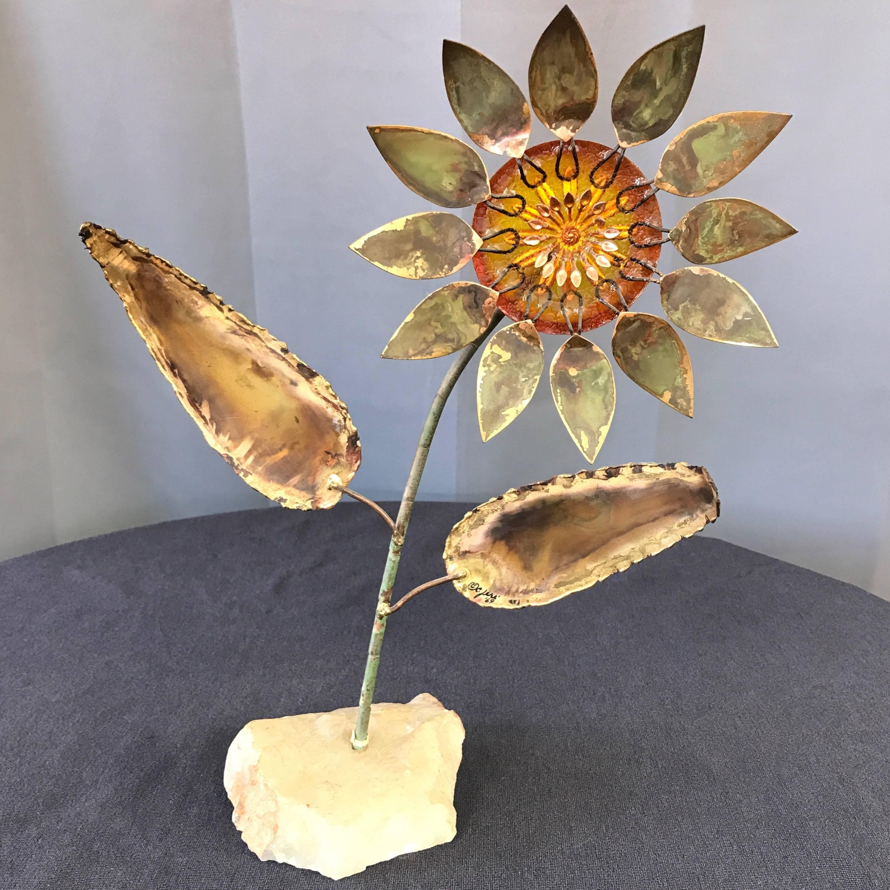 A signed and dated rare sunflower sculpture in brass, copper, and resin with onyx base by midcentury California artist collaborative Curtis Jére.

Stylized brass petals and copper seeds are set in translucent amber cast resin. Copper stem with