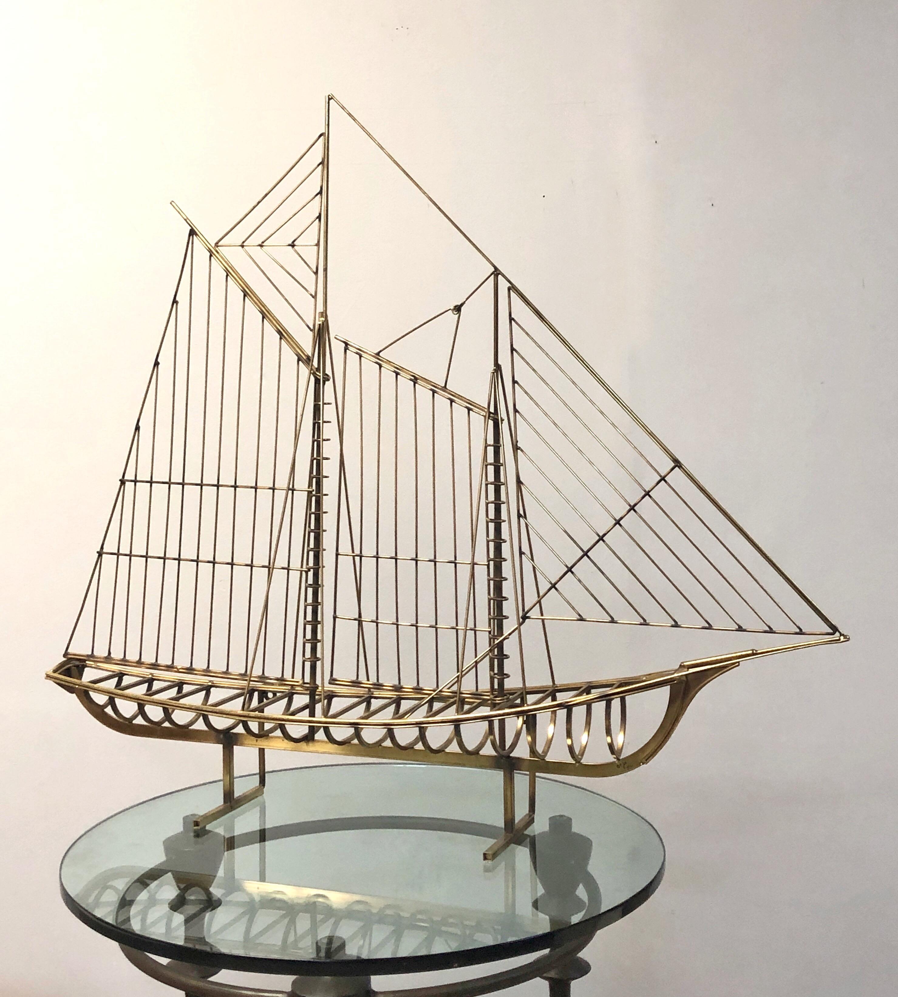 A vintage 1976 boat sculpture by Curtis Jere. Could be displayed on top of a piece of furniture or wall hanging. The hanging bracket is removable for a cleaner table top look. Brass finish. Signed and dates.