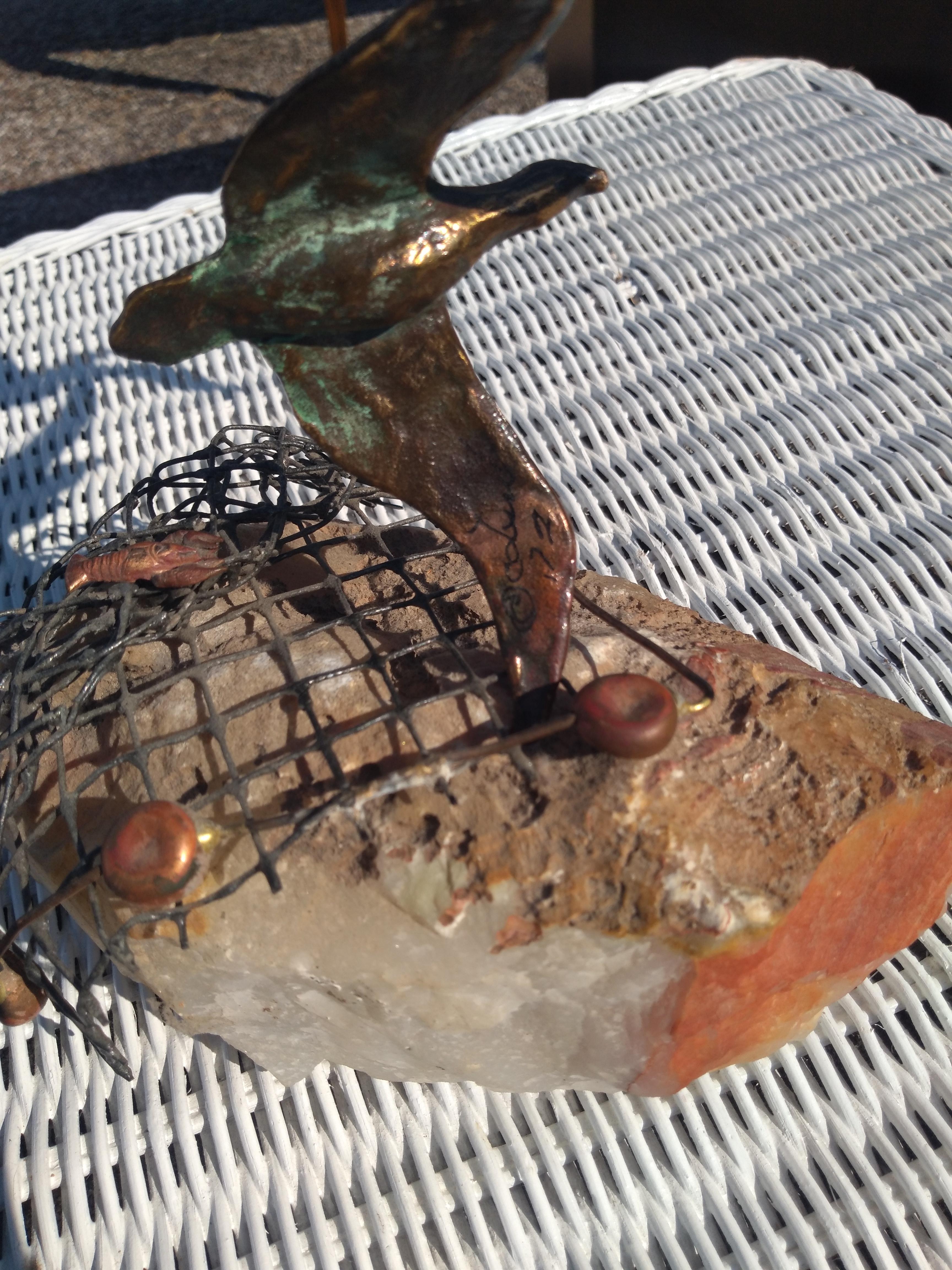 Questa scultura è stata realizzata da Curtis Jere. È scolpito in metallo e attaccato a una roccia. Alla roccia è attaccata una rete da pesca in metallo a maglie metalliche. In alto ci sono 3 gabbiani scolpiti che prendono il volo. L'opera è firmata