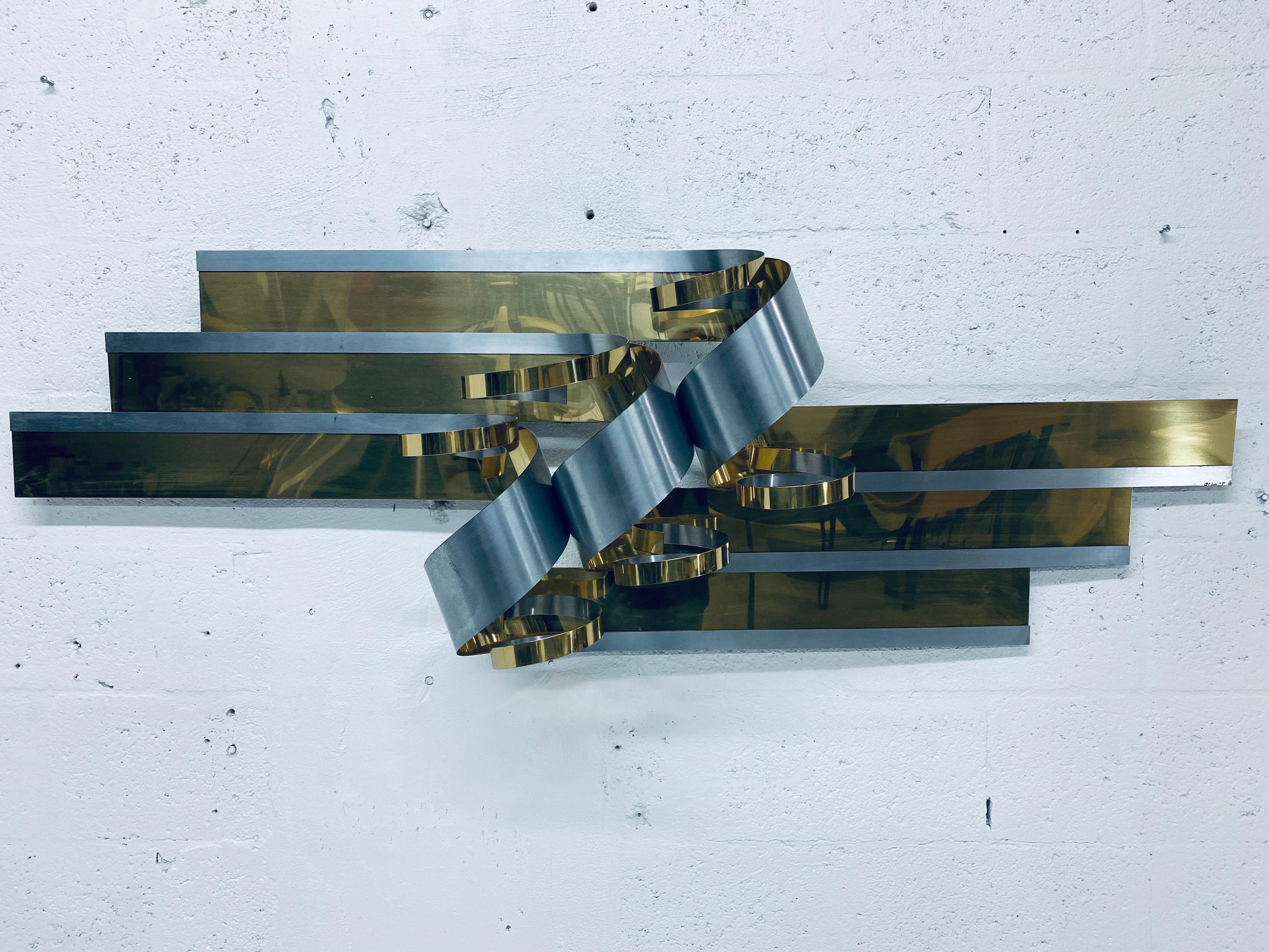 Curtis Jere ribbon wall sculpture made of brass and steel, 1989. Can be hung horizontal or vertical.