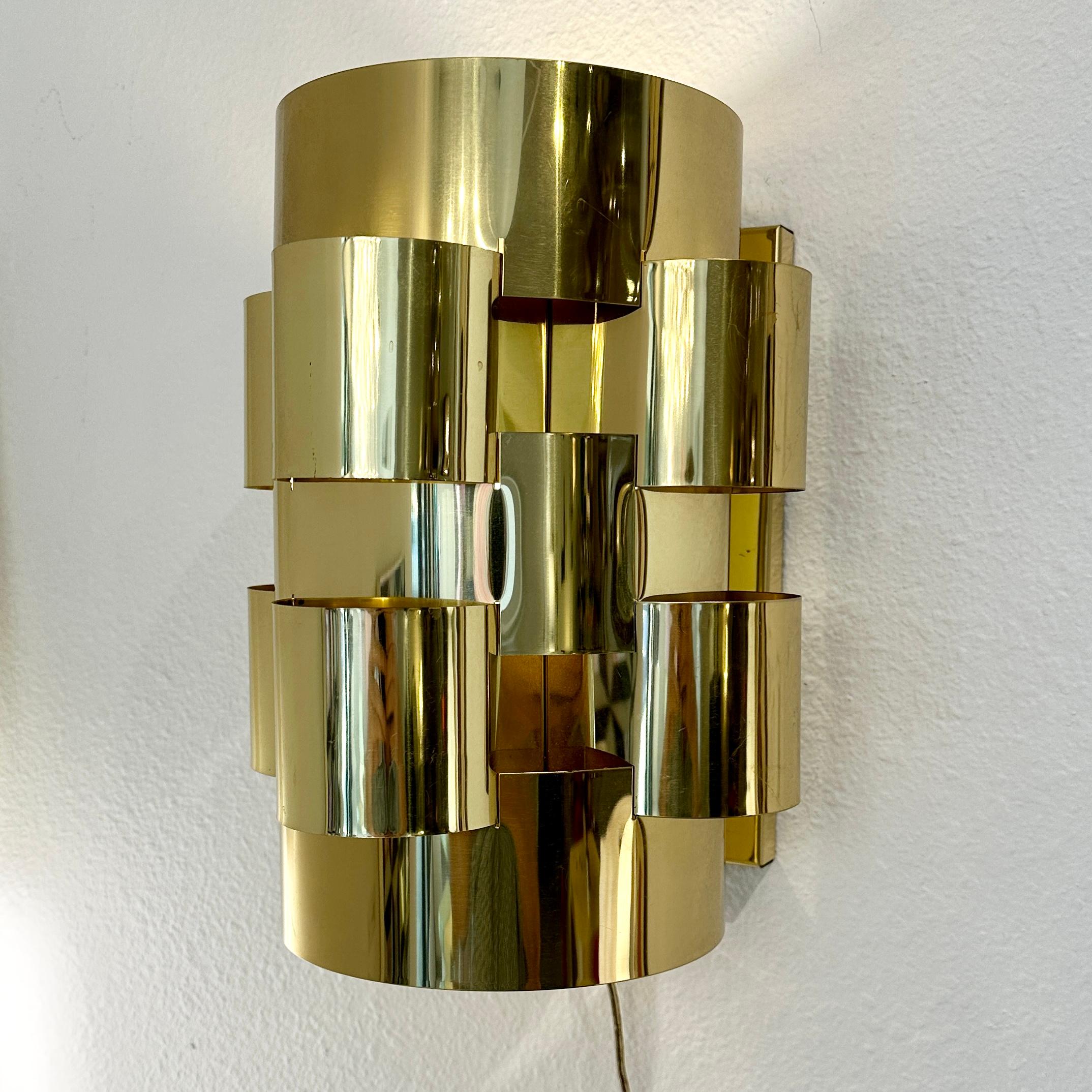 Curtis Jere Brass Cloud Sconce, Signed and Labeled,  ca 1980s.

This Curtis Jere Sconce is an excellent example of late modern design.  Brass plated ribbons create a sculptural shape reminiscent of 80s elegance.  

Although the fixture is