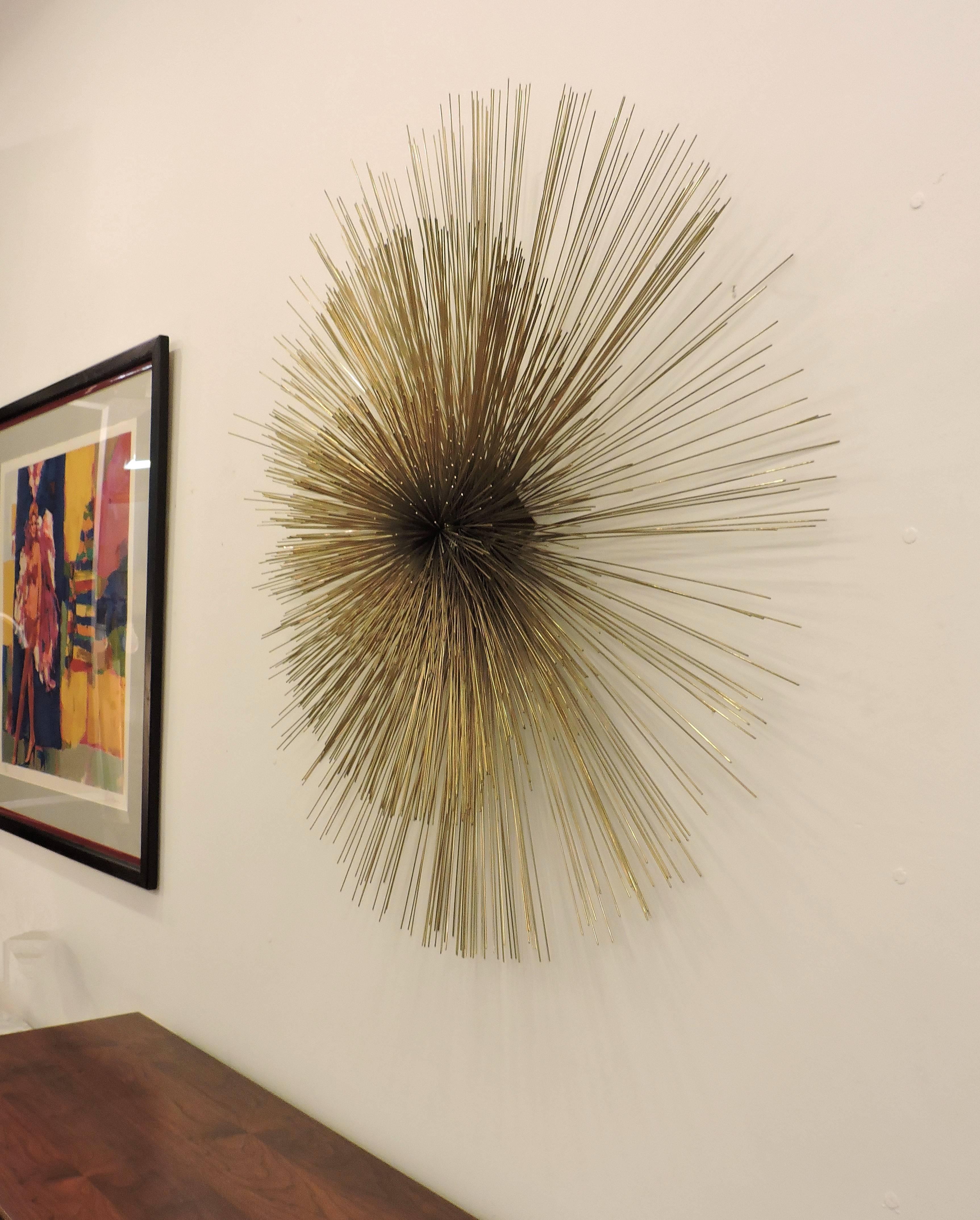 Large and striking brass wall sculpture designed and made by Curtis Jere. This sculpture has hundreds of thin brass rods welded together to make a huge dimensional starburst. 
Signed C. Jere, 1987.