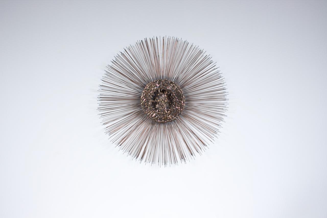 Curtis Jeré, William Friedle Style Brass plated Starburst Wall Relief.  Featuring a handcrafted radiating circular form, with central three dimensional organic Brass orb, torch cut Copper toned, varied length Iron wire, with tipped sunburst rays