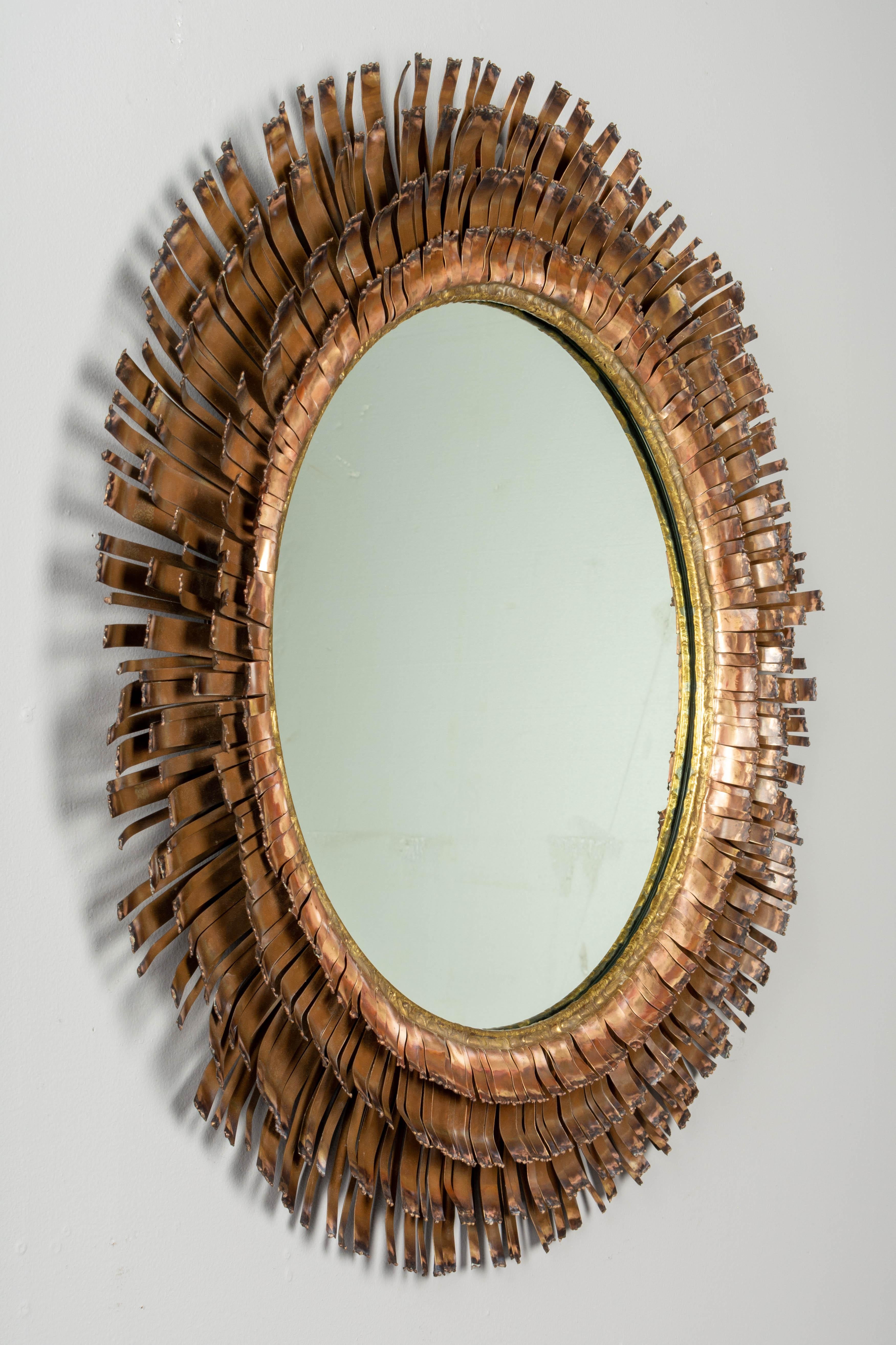 A rare Brutalist style eyelash mirror wall sculpture by Curtis Jere, handcrafted of four concentric layers of patinated copper sheeting cut into fringe-like strips with torched edges. Beautiful warm copper and brass patina. Signed C. Jere 1970 and