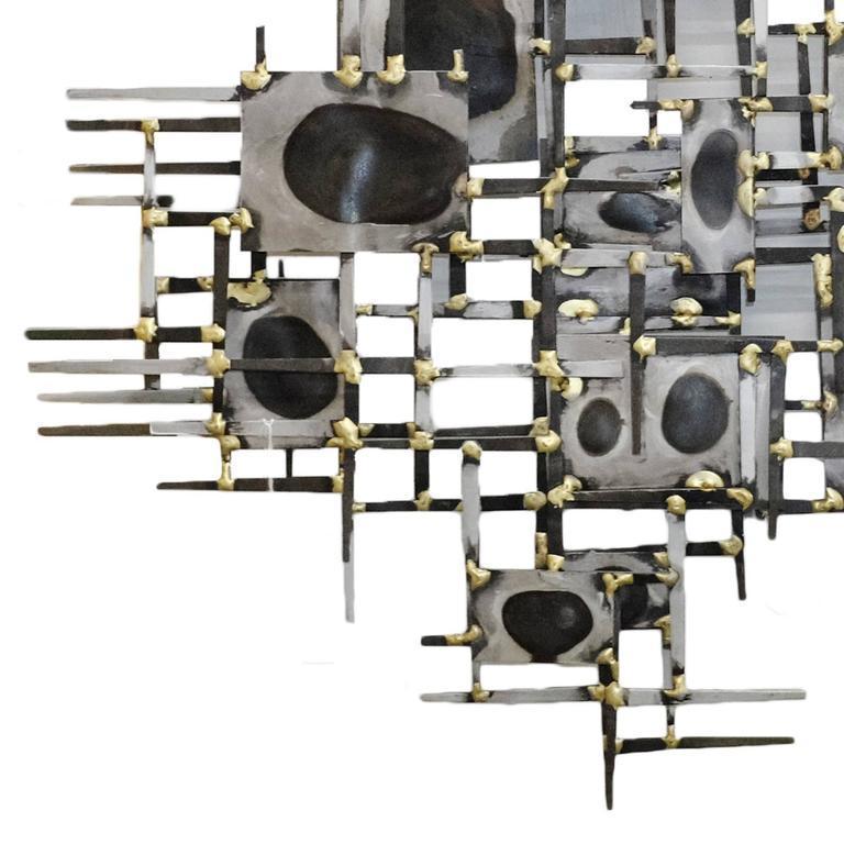 Originally designed by Curtis Jere for Artisan House in the 1950s, this iconic “Troy” asymmetric nail wall sculpture features a mix of iron nails, sheet metal, and brass accents.

By Artisan House.