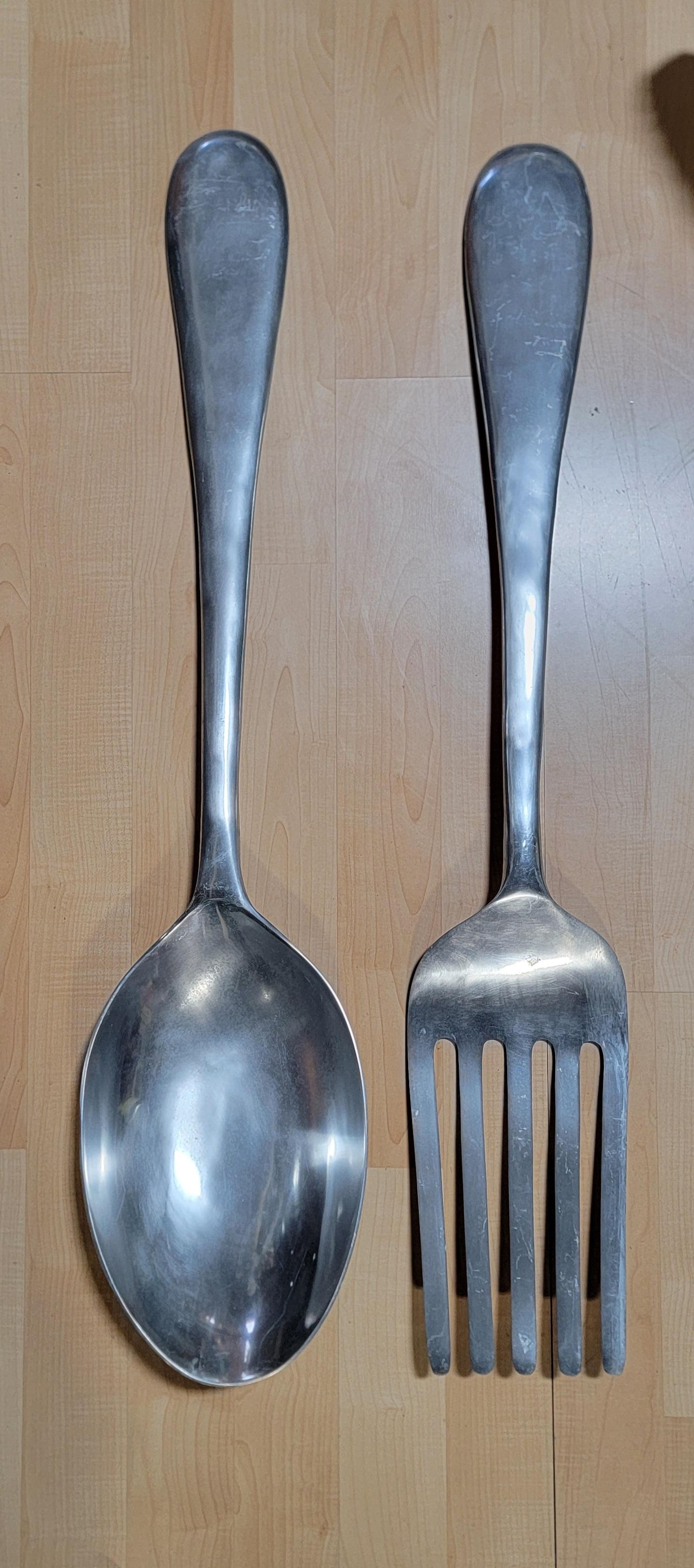A set of 2 cast aluminum fork and spoon wall sculptures by Curtis Jere. Large-scale measures 46 inches high. Fun for home kitchen or commercial restaurant decor.

Fork:
45.63 inches high.
8.25 inches wide.
1.75 inches deep.
Spoon:
46.63 inches