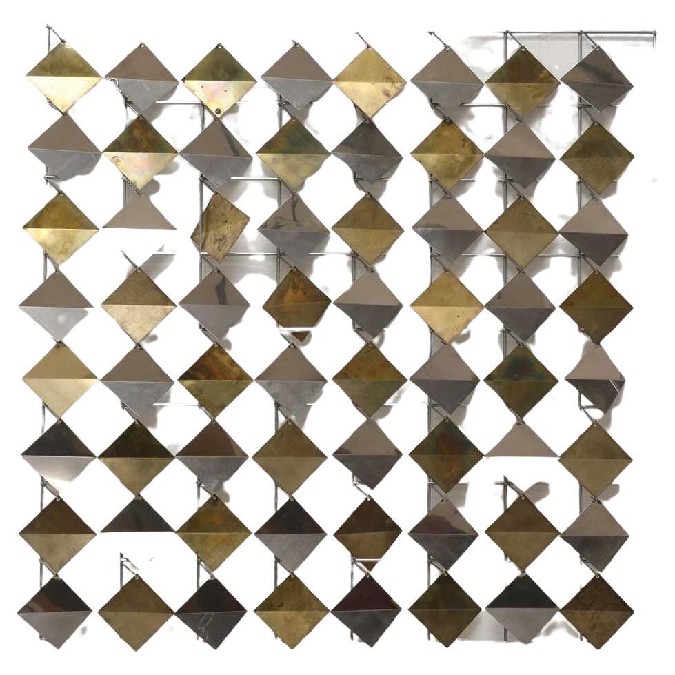 'Diamonds' by Curtis Jeré, a dynamic wall piece of brass and chromed steel embraces both kinetic and brutalist art to create a piece that celebrates its materials, movement and sound. 

Created in the studio of Curtis Jeré also known as C. Jeré, a