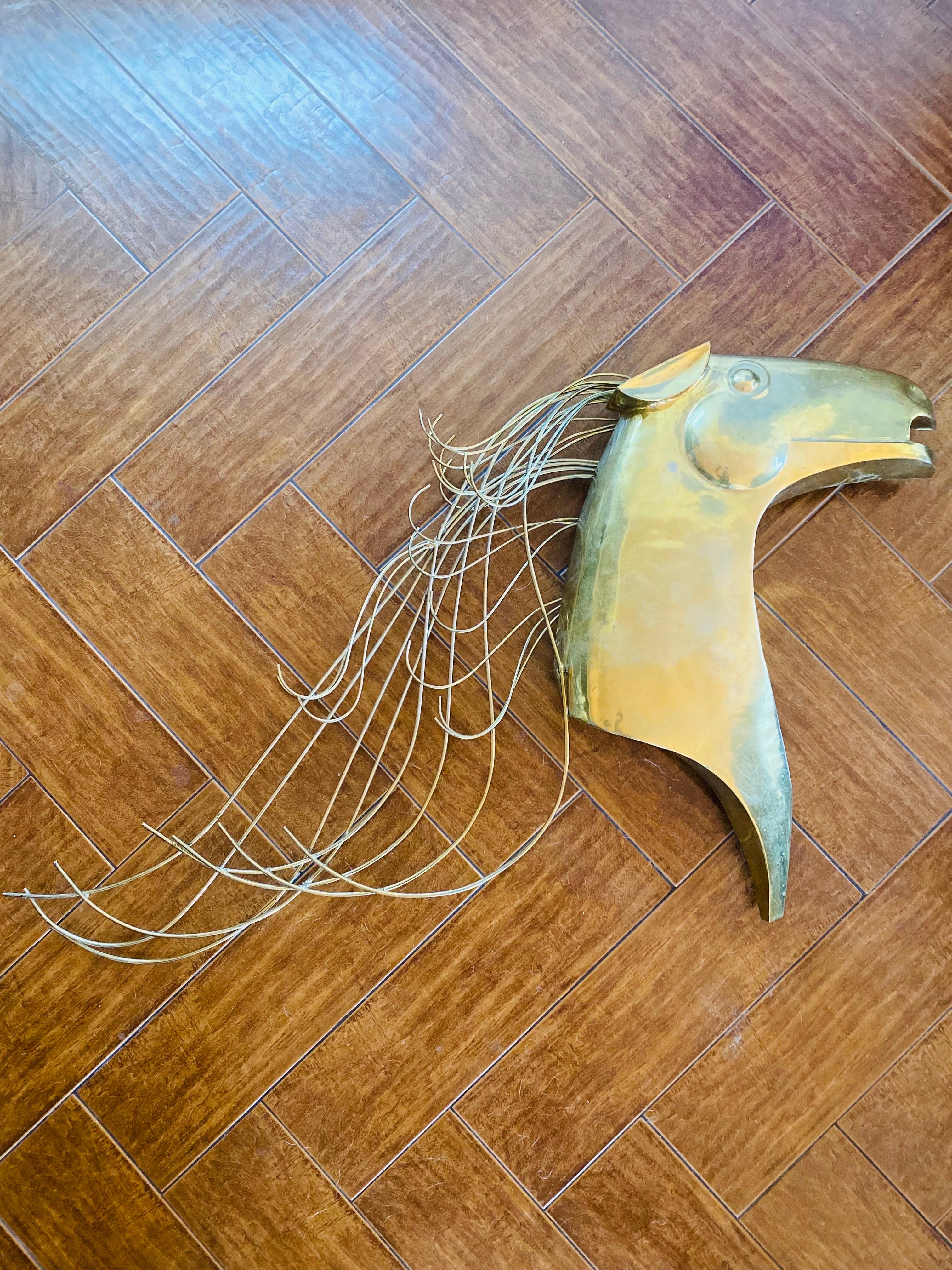 Escultura mural Curtis Jere de caballo dorado. Esta pieza está firmada en una varilla de la crin con C. Jere 1989, escultura mural de latón de caballo estilizado.  Hermosa pieza escultórica que aporta elegancia y evoca movimiento y libertad.