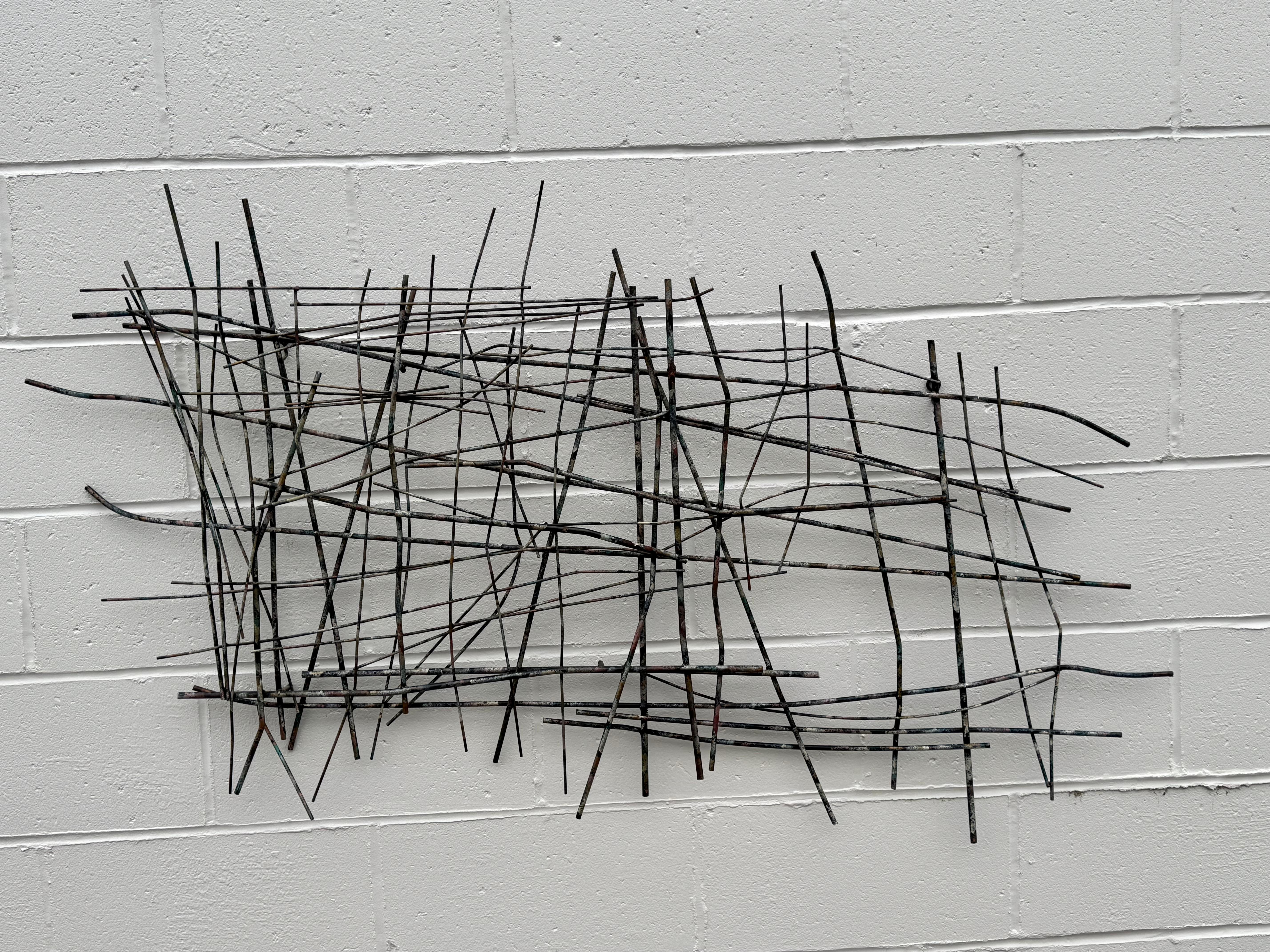 Grande scultura astratta da parete in acciaio firmata Steele Jeré, in stile metà secolo moderno. Realizzato con strati di varie dimensioni di aste metalliche che si intersecano e che sono state dipinte in modo colorato. Le composizioni attorcigliate