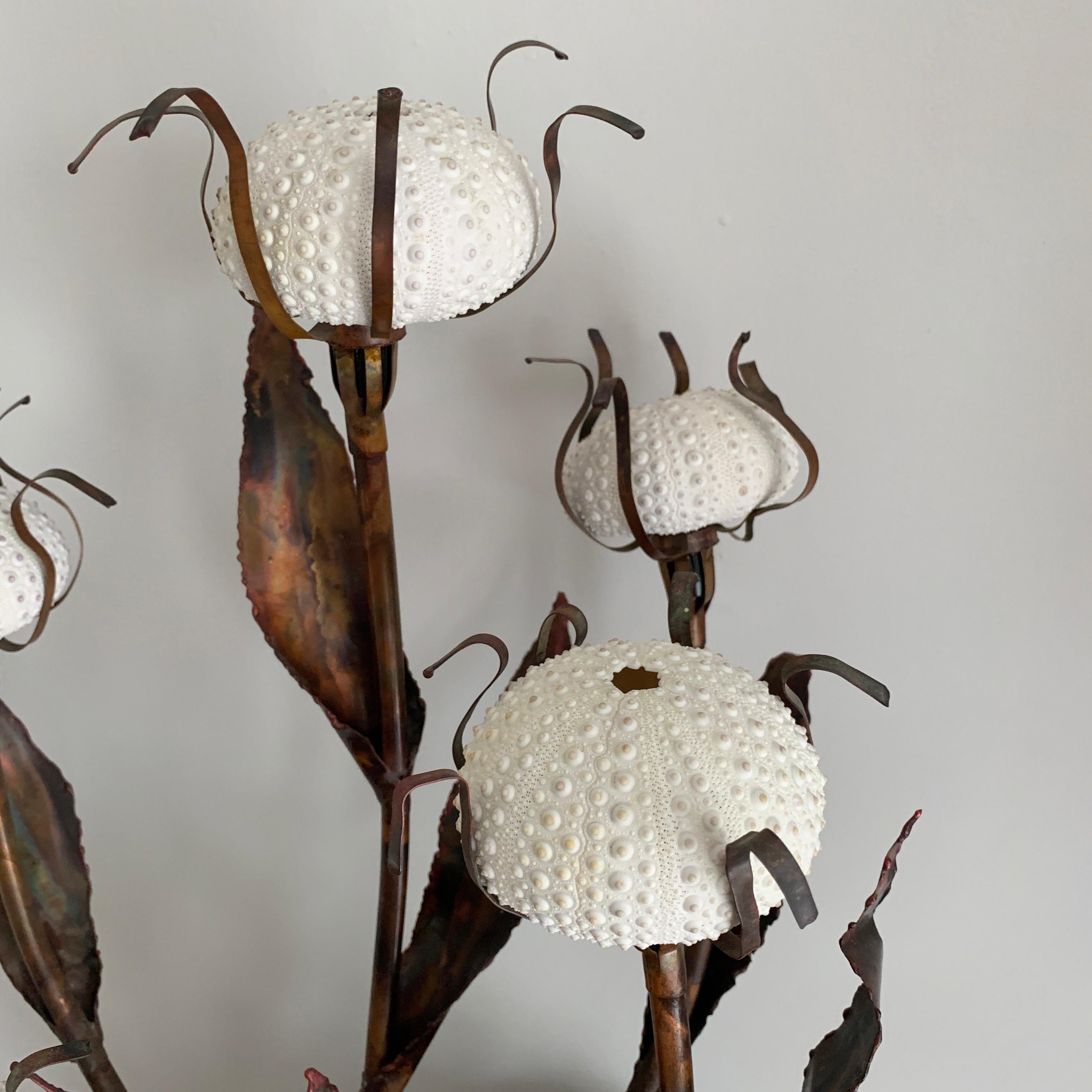 Curtis Jere Sea Urchin table lamp,
circa 1960s-1970s
A fantastic composition of naturalistic stems and leaves in patinated copper carrying five lights made of real sea urchin shells held in place with petal like forms.
When the lights are on the