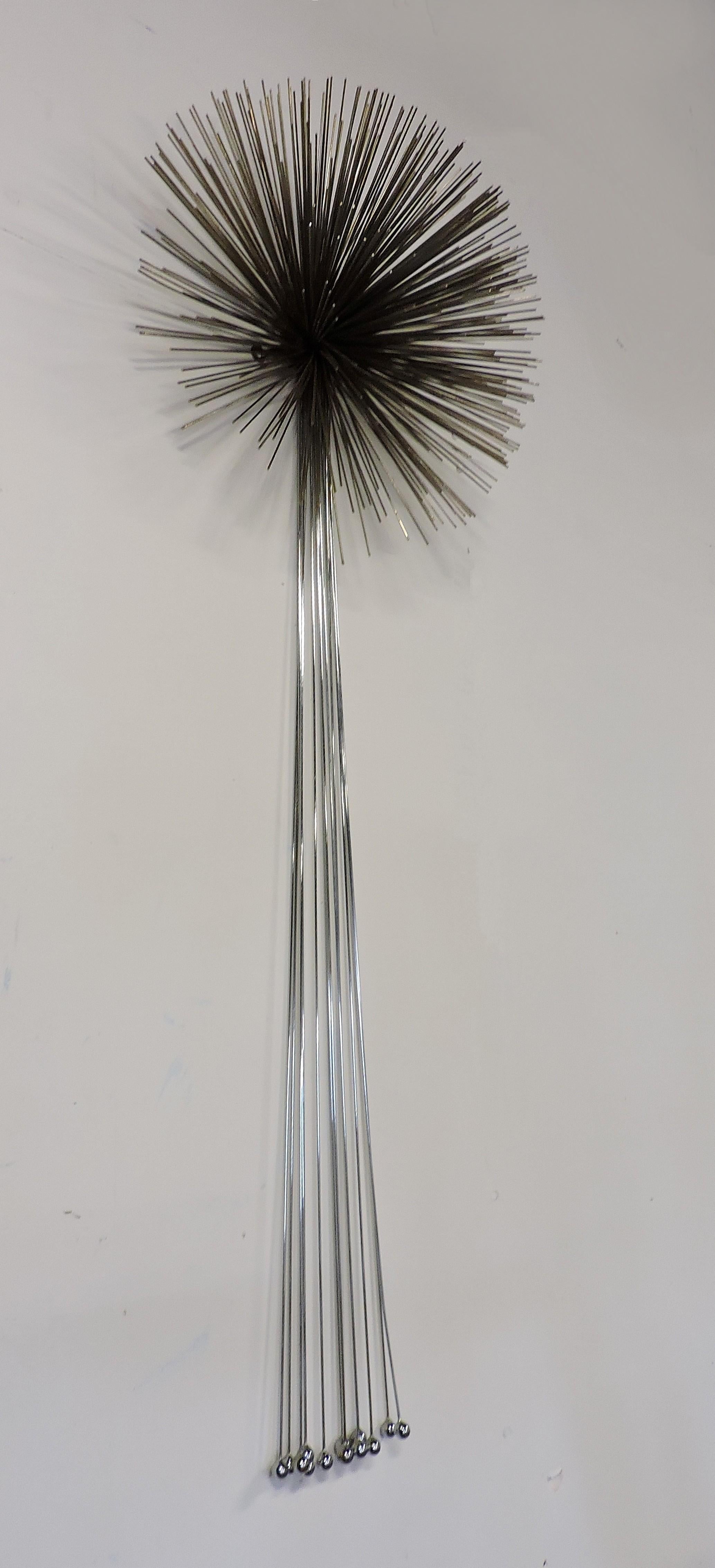 Large and striking mixed metal wall sculpture designed and made by Curtis Jere. This sculpture has thin metal rods welded together to make a dimensional starburst which has attached chrome wire and balls.
Signed C. Jere, 1989.