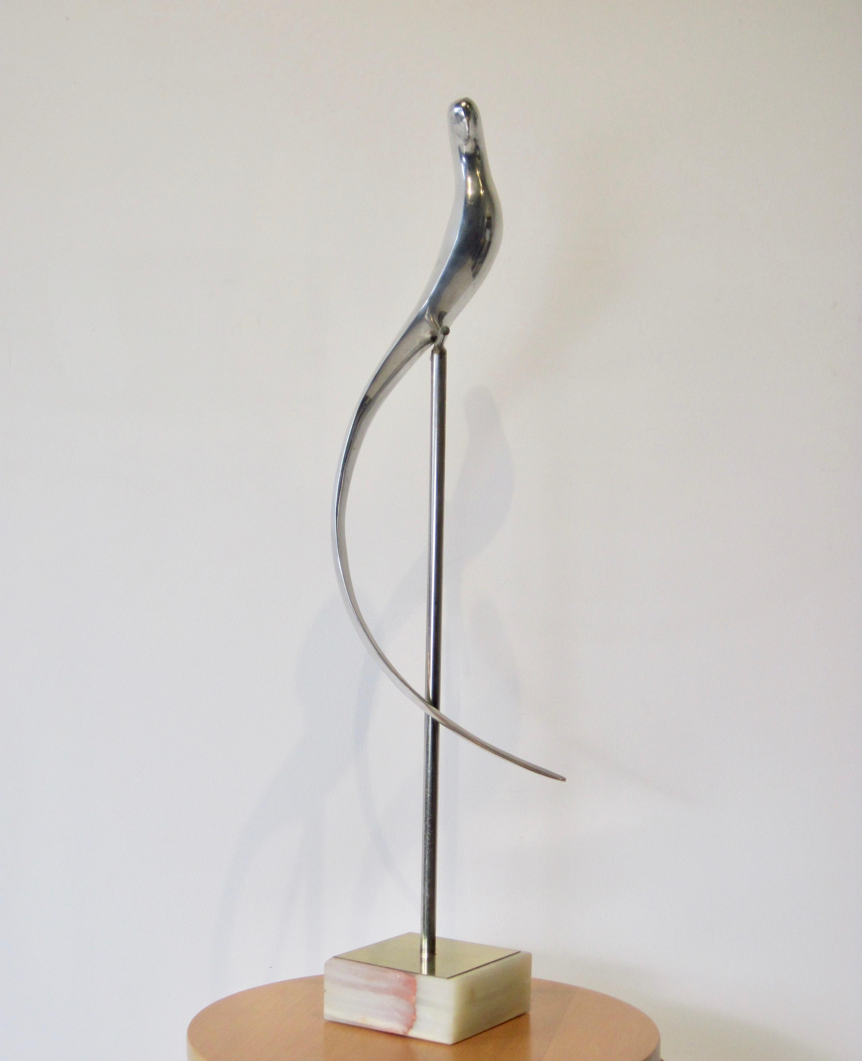 A solid aluminum stylized parrot on a perch sculpture by Curtis Jeré. The elongated curved feathers are elegantly dramatic. Square marble base with brass finishing detail. This item is two pieces and will be wrapped separate within one box for