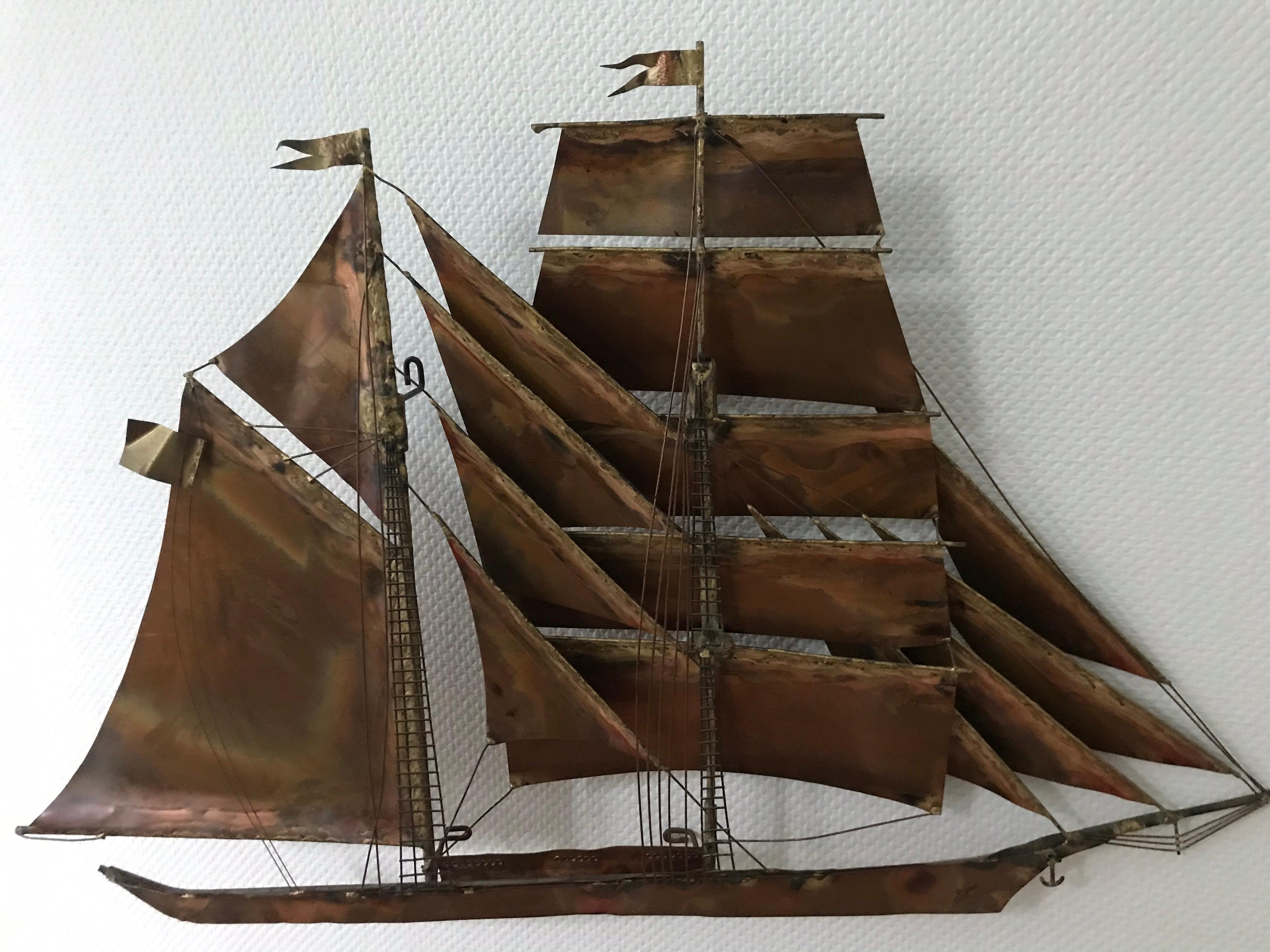 This is a copper and brass sculpture of a clipper ship and is made to hang on wall or sit on table It was made and signed by Curtis Jere.