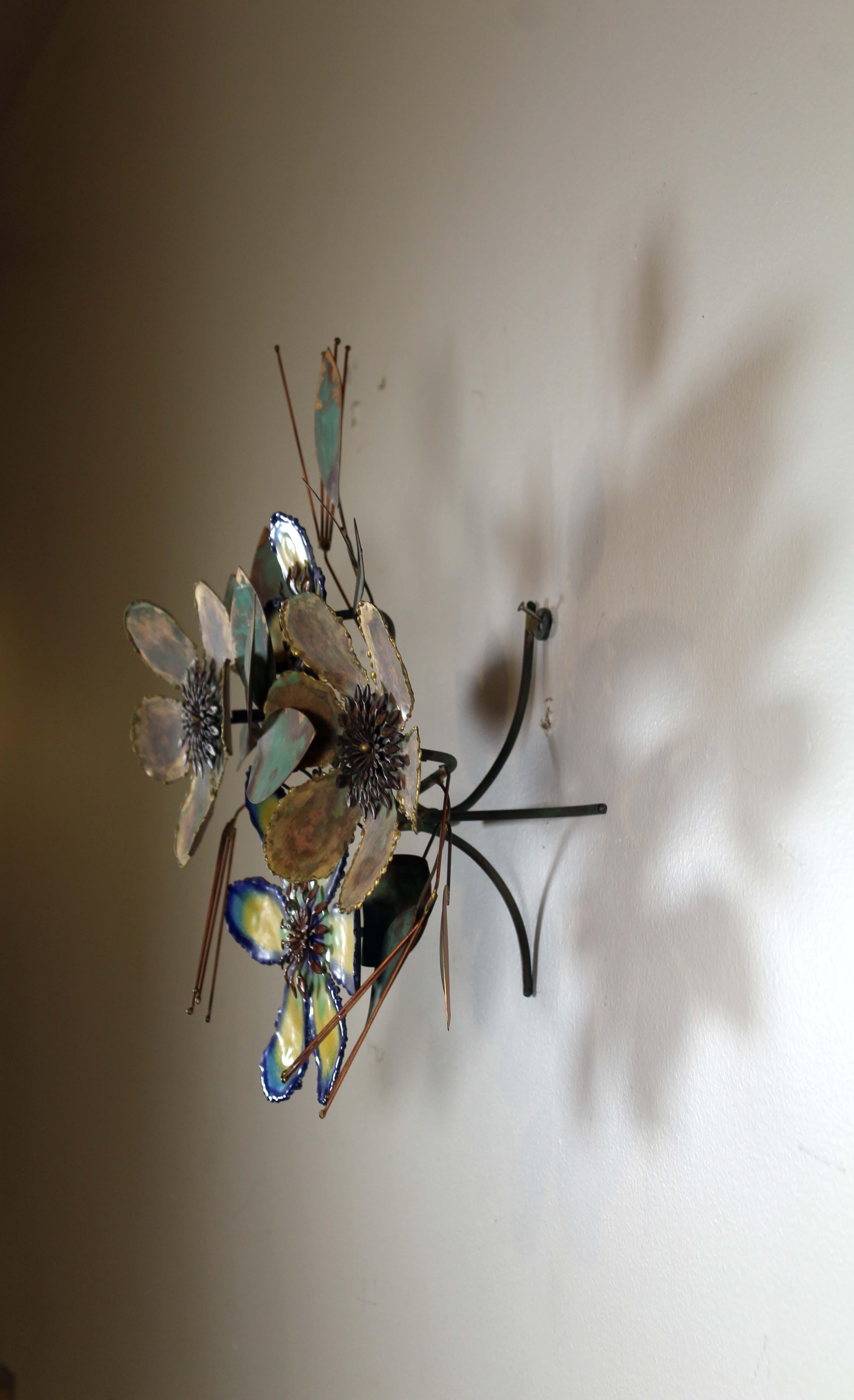 An iconic design of the Mid-Century Modern era, a metal wall sculpture by Curtis Jere. Signed on the leaf with a 1969 date. The sculpture elevates off the the wall and has a floral design that pops with yellow and shades of turquoise hues. There is