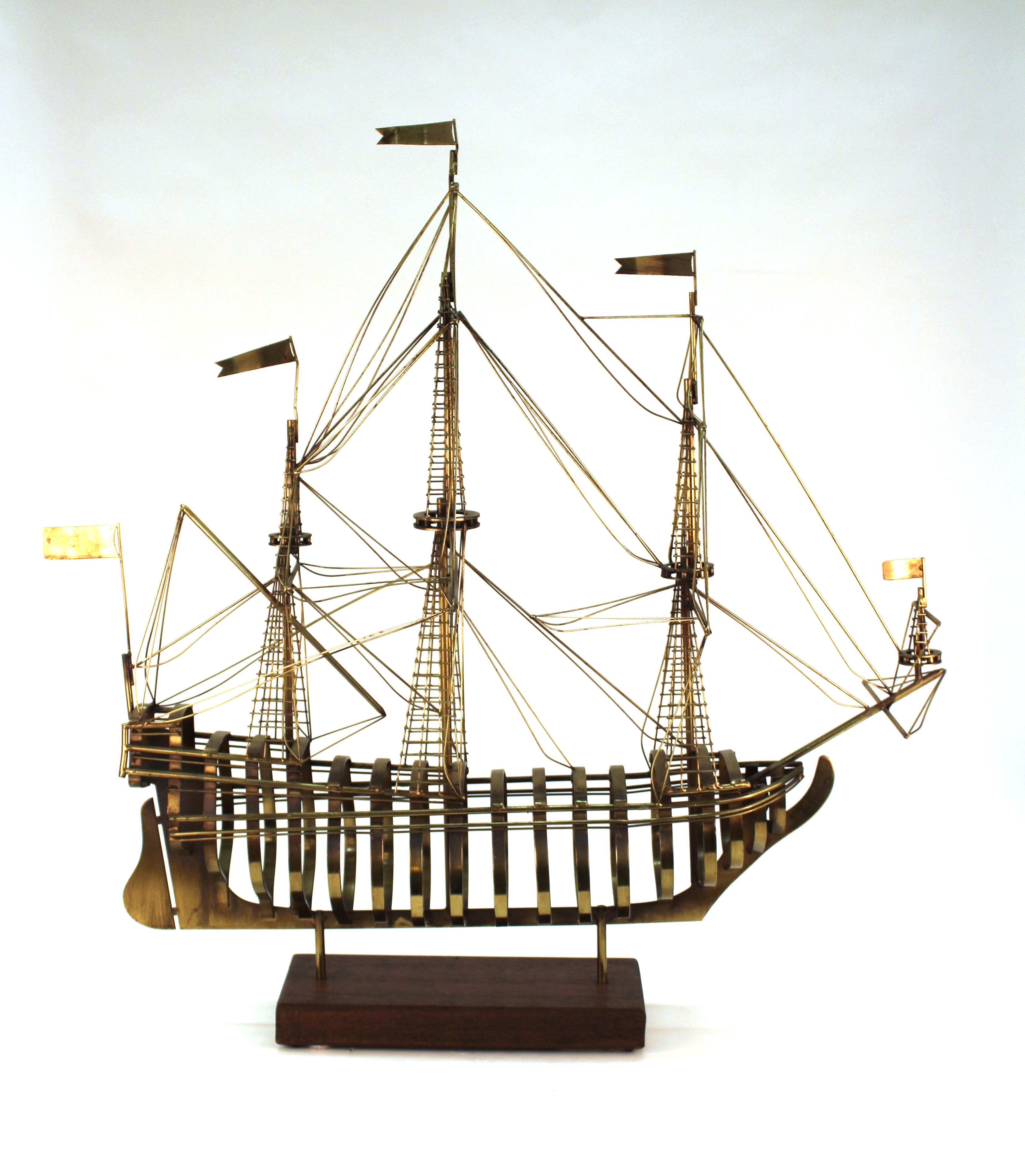 Modern style brass sculpture of a ship model atop a wooden base, made by Curtis Jere, signed and dated 1980 on the back. The piece is highly detailed and is in great vintage condition, with some age-appropriate wear to the patina of the brass.