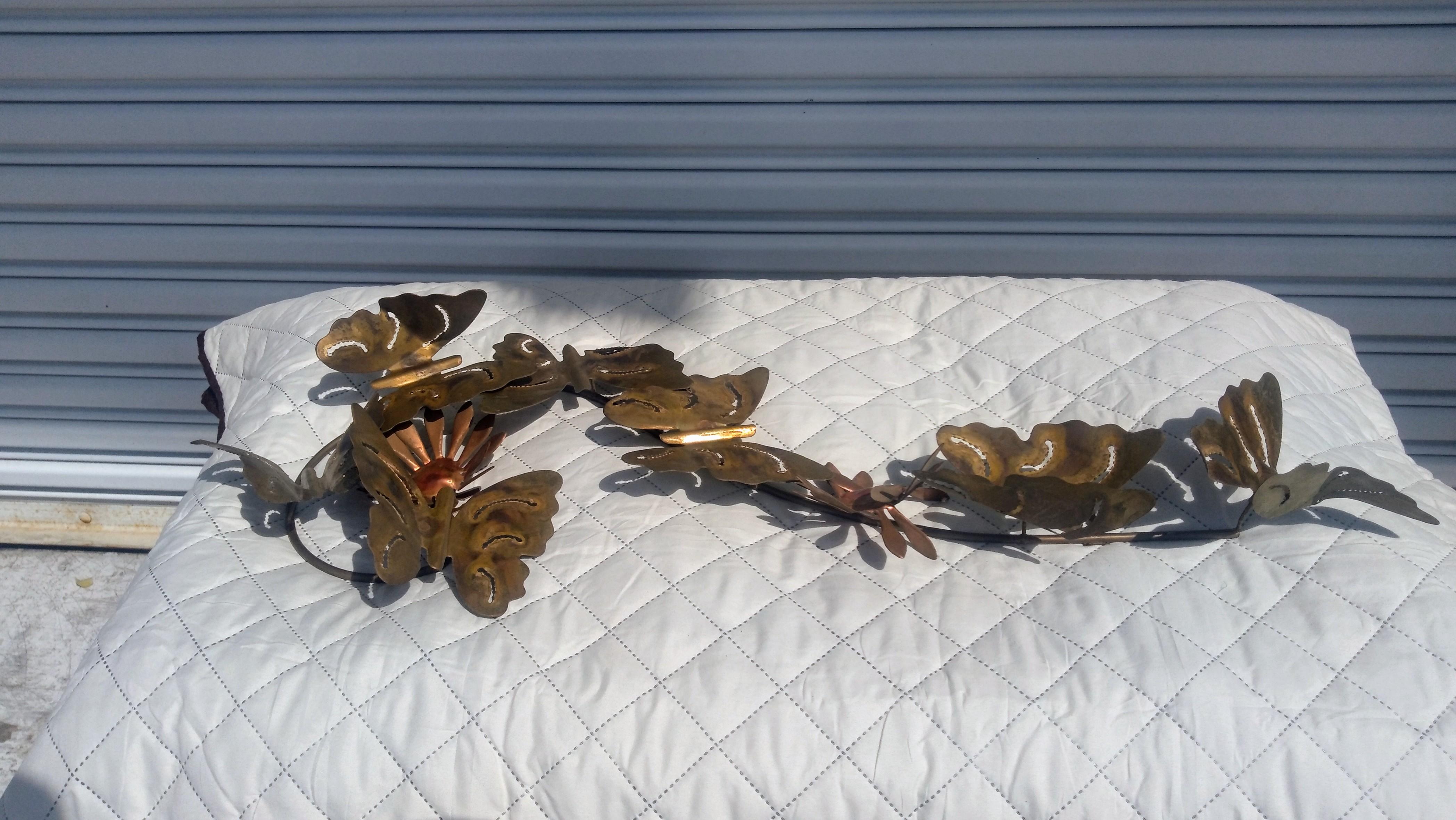 This wall sculpture is done in the style of Curtis Jere. It has flowers, butterflies and leaves all done in different metals. 

Makes a nice mid century addition to your decor.