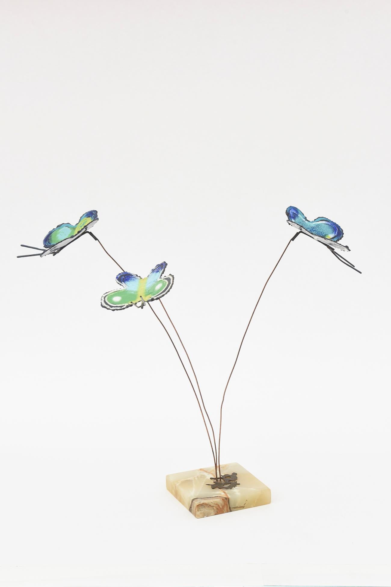 This unusual and rarely found vintage signed Curtis Jere sculpture has enameled butterflies coming from 3 wire points that sit in the original marble base. The colors of shades of sea green, green, turquoise, blues, yellows and with white are the