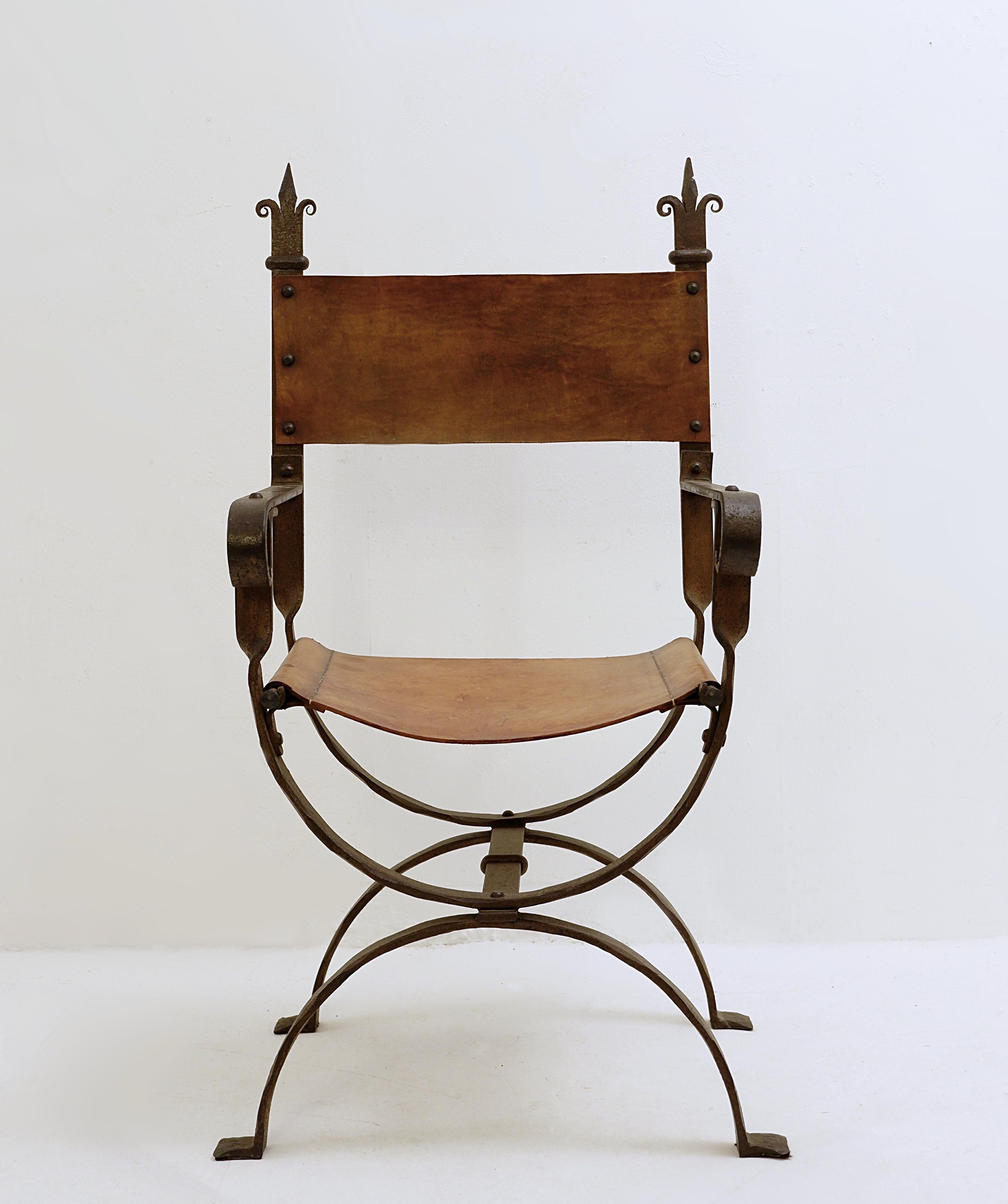 Curule armchair in wrought iron and leather.
