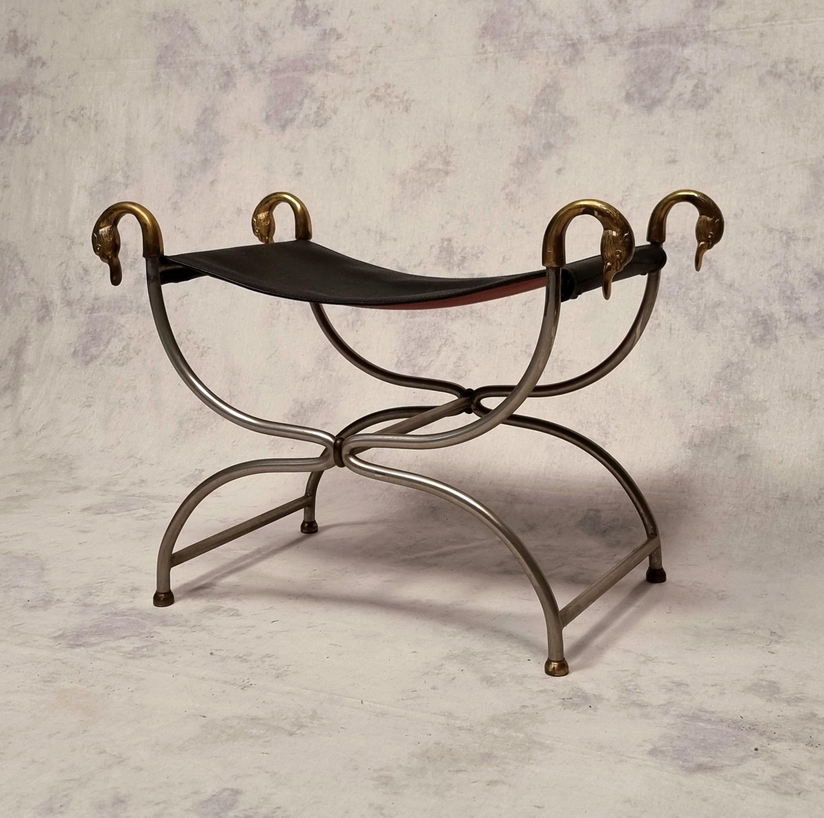 Stool from Maison Jansen in the neoclassical style. This curule stool dates from the 1950s. This superb model, whose structure is made of steel, is decorated with bronze swan necks on the four uprights. The seat is in quality stretched leather. The