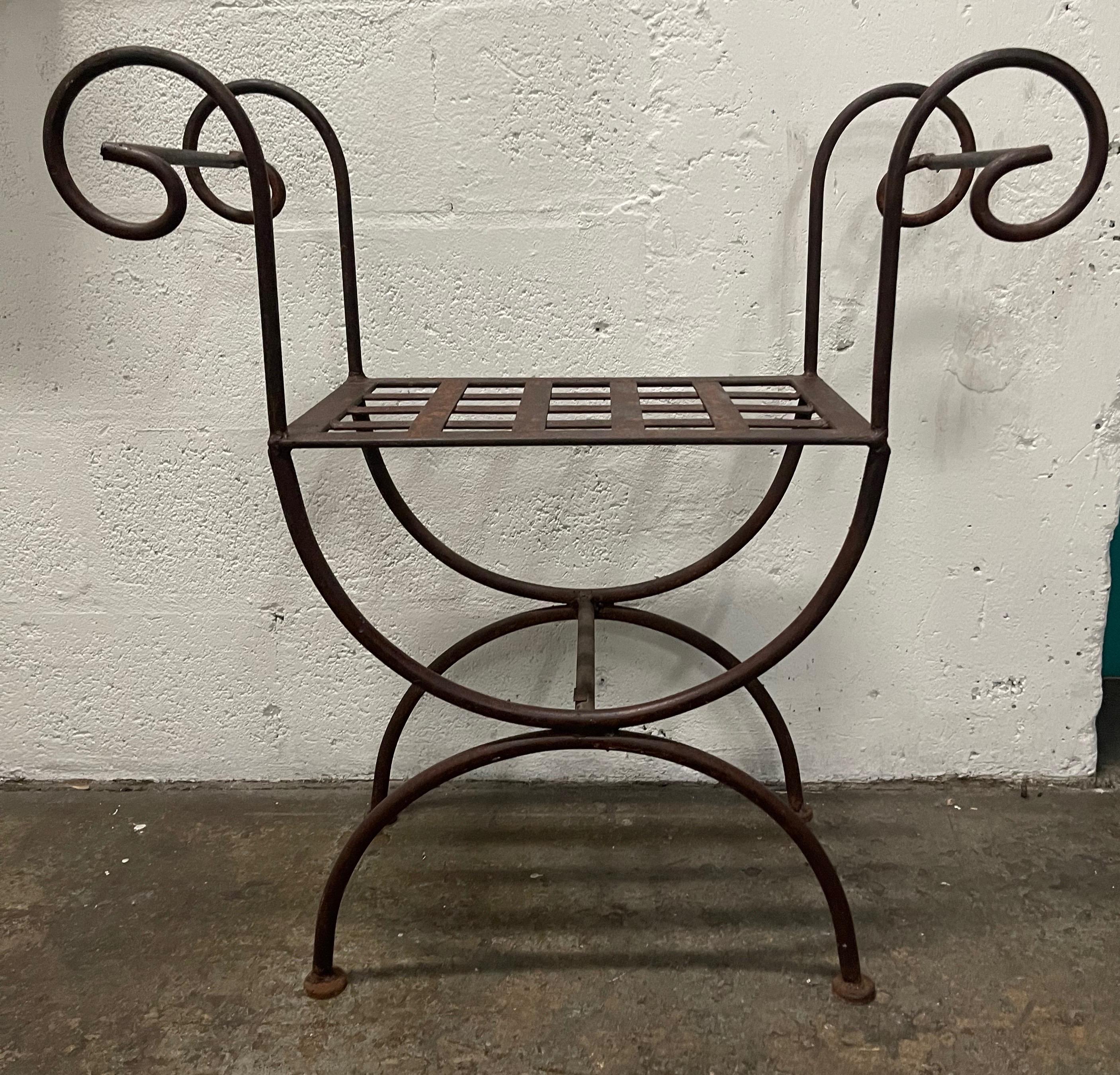 Curule style naturally patinated iron bench with curved arms & lattice seat.