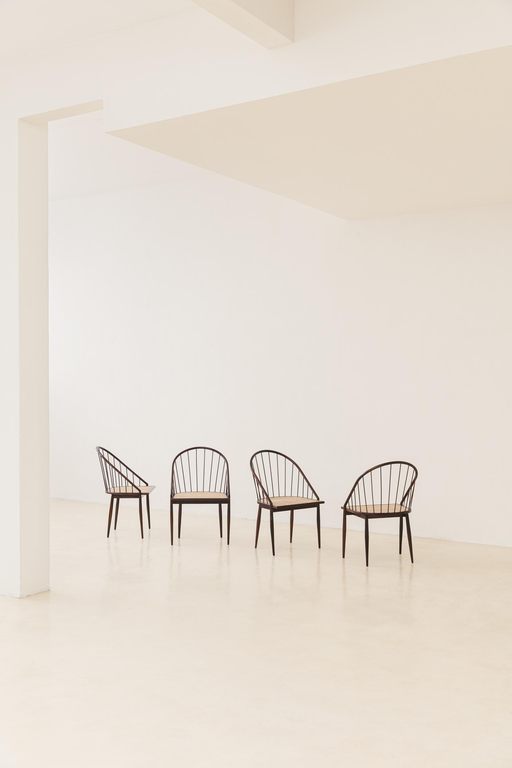This exquisitely crafted rosewood curved chair with stick back designed by Joaquim Tenreiro (1906-1992) in 1961/1962 evokes a refined coexistence of traditional values and modern aesthetics. Its delicate shapes, with the backs of thin sticks and the
