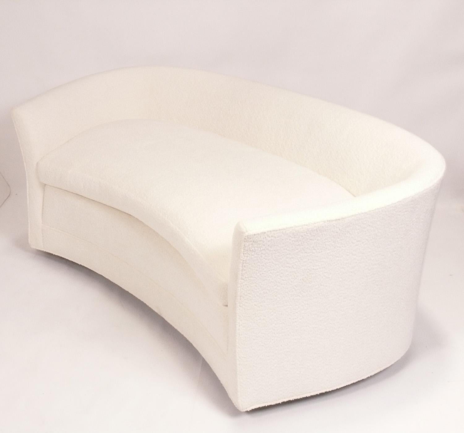 Curvaceous Mid Century Settee or Sofa, in the manner of Vladimir Kagan, American, circa 1960s. It has recently been reupholstered in an ivory white color boucle fabric. 