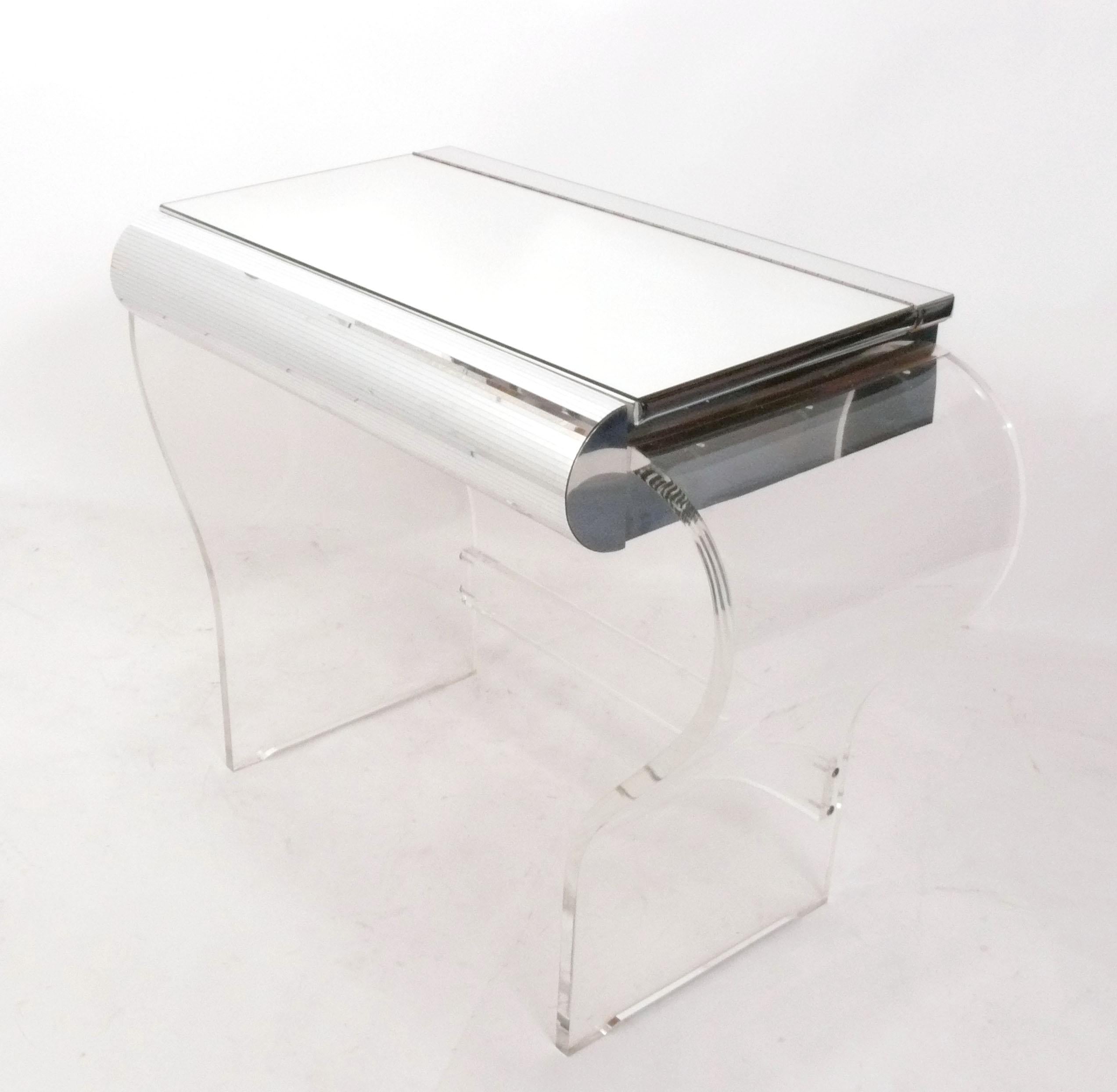 Curvaceous Lucite or Acrylic and Mirrored Vanity, in the style of Karl Springer, American, circa 1960s. The table top swings open to reveal a mirror and it has a mirror tiled drawer that opens. It is a versatile size and could be used as a vanity,