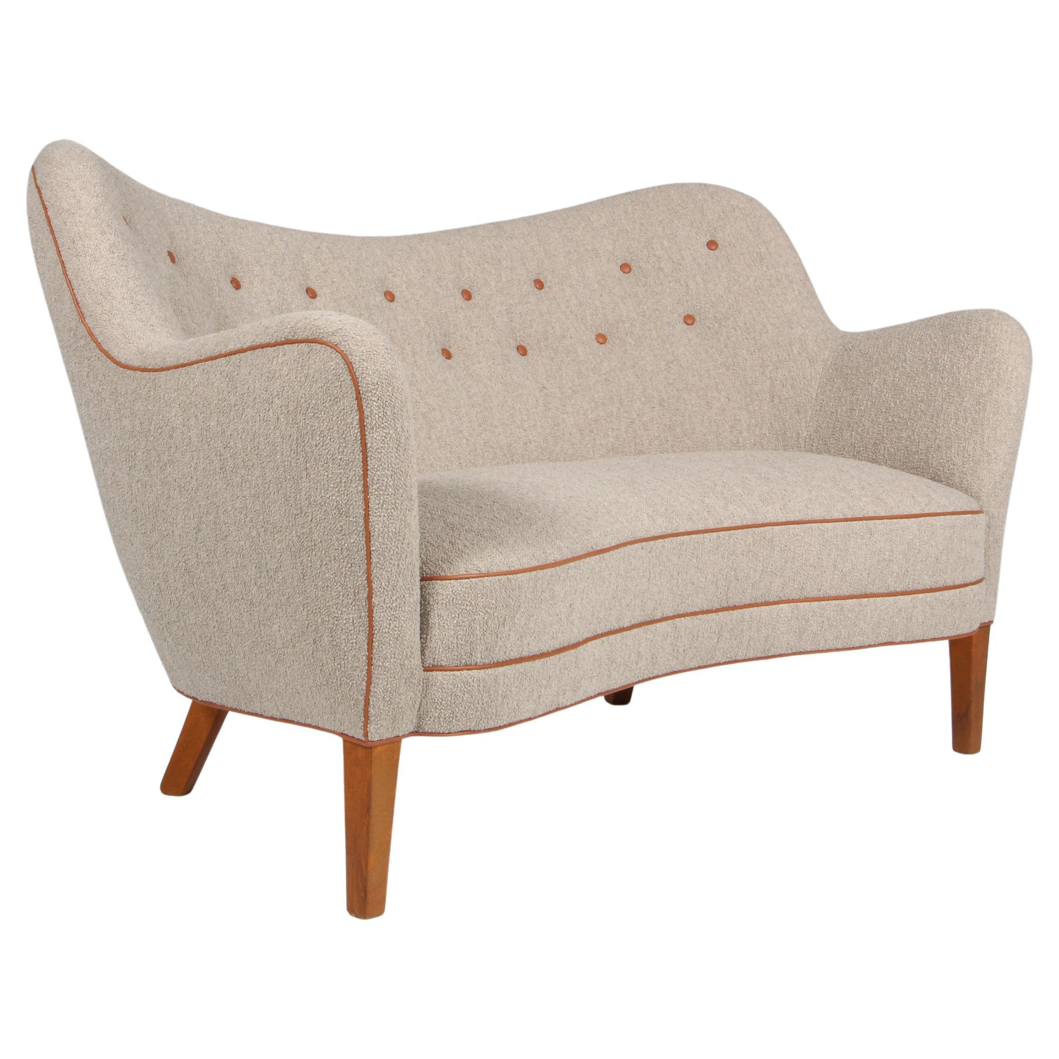 Slagelse Møbelværk two seat love sofa new upholstered with bouclé and cognac aniline tubing and buttons. 

Legs of stained beech.

This sofa is made in the 1950s and is made in the style of Finn Juhl.