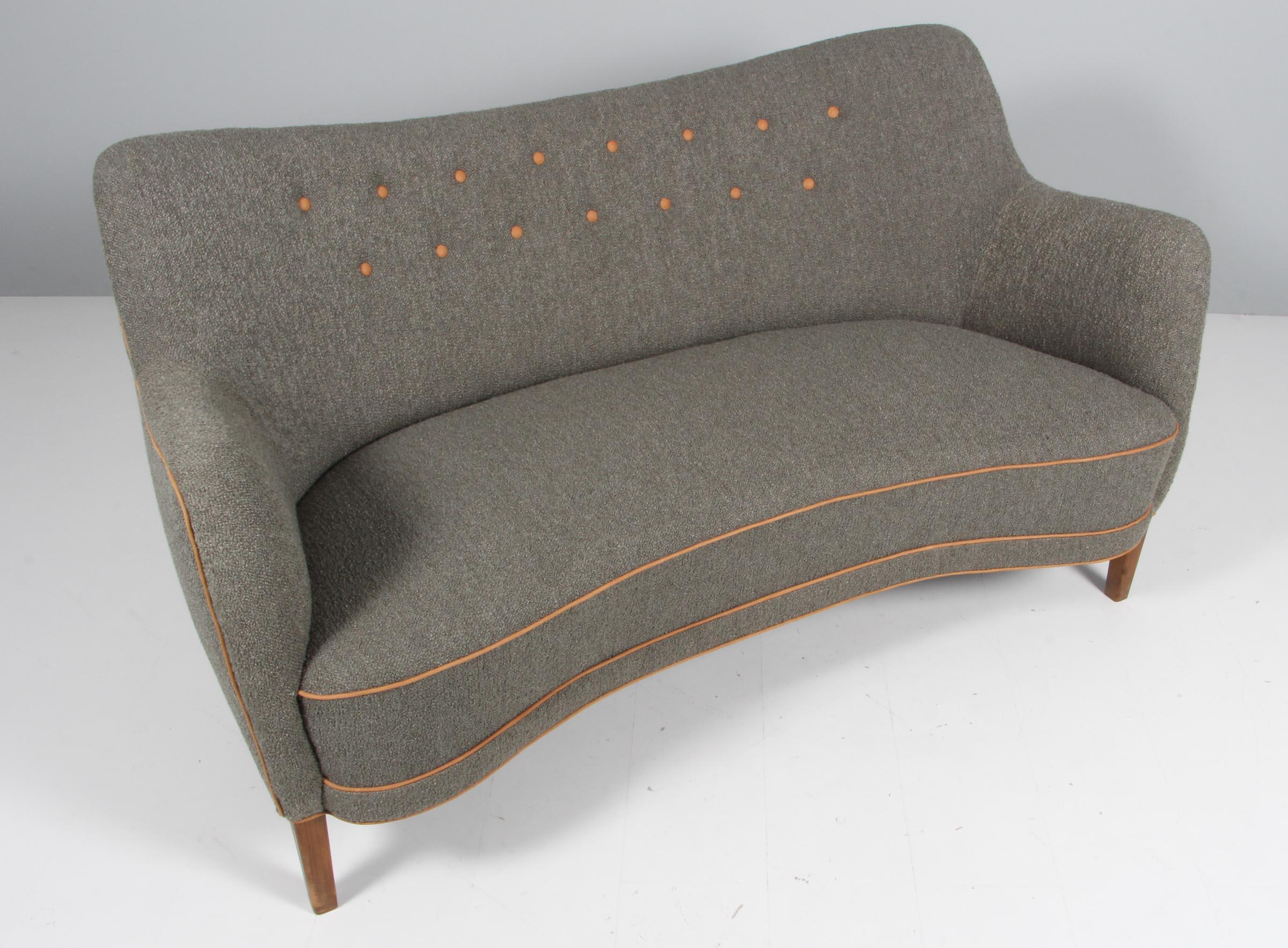 Slagelse Møbelværk two seat love sofa new upholstered with bouclé and cognac aniline tubing and buttons. 

Legs of stained beech.

This sofa is made in the 1950s and is made in the style of Finn Juhl.