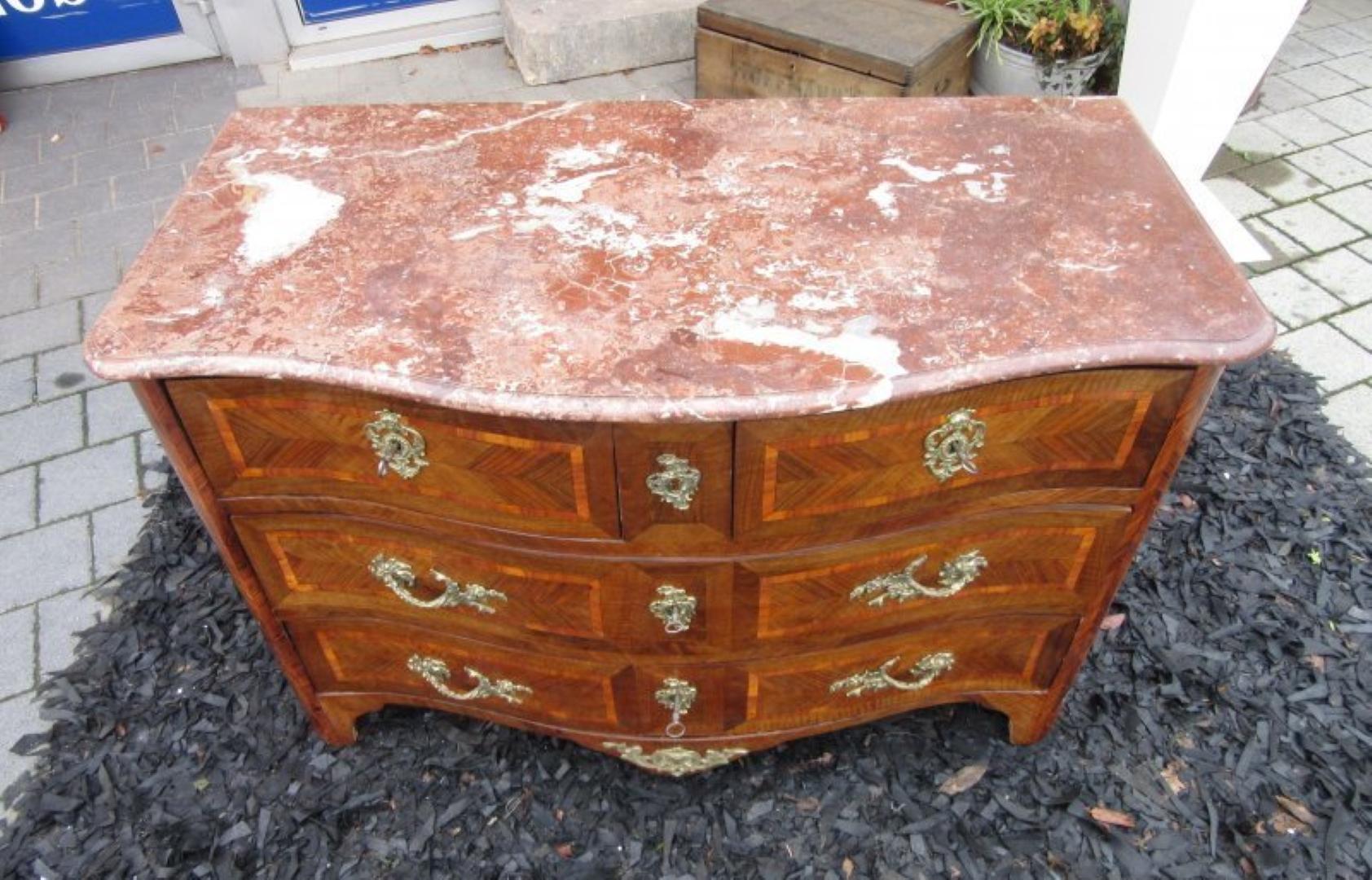 Original antique Baroque chest of drawers or commode from the 1780s with a curved front. Features stunningly worked original brass handles, key plates and wonderful ornamentations. The body is build out of massive oakwood veneered with luxurious