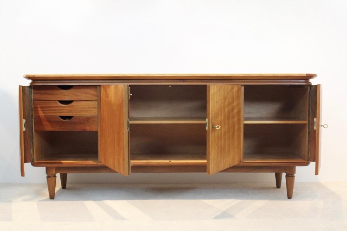 Elegant and sophisticated Art Deco sideboard in teak in very good vintage condition, some normal user marks consistent with age and use. Attractive mixture of different structures on the doors. The doors of the cabinet are magnificently curved to