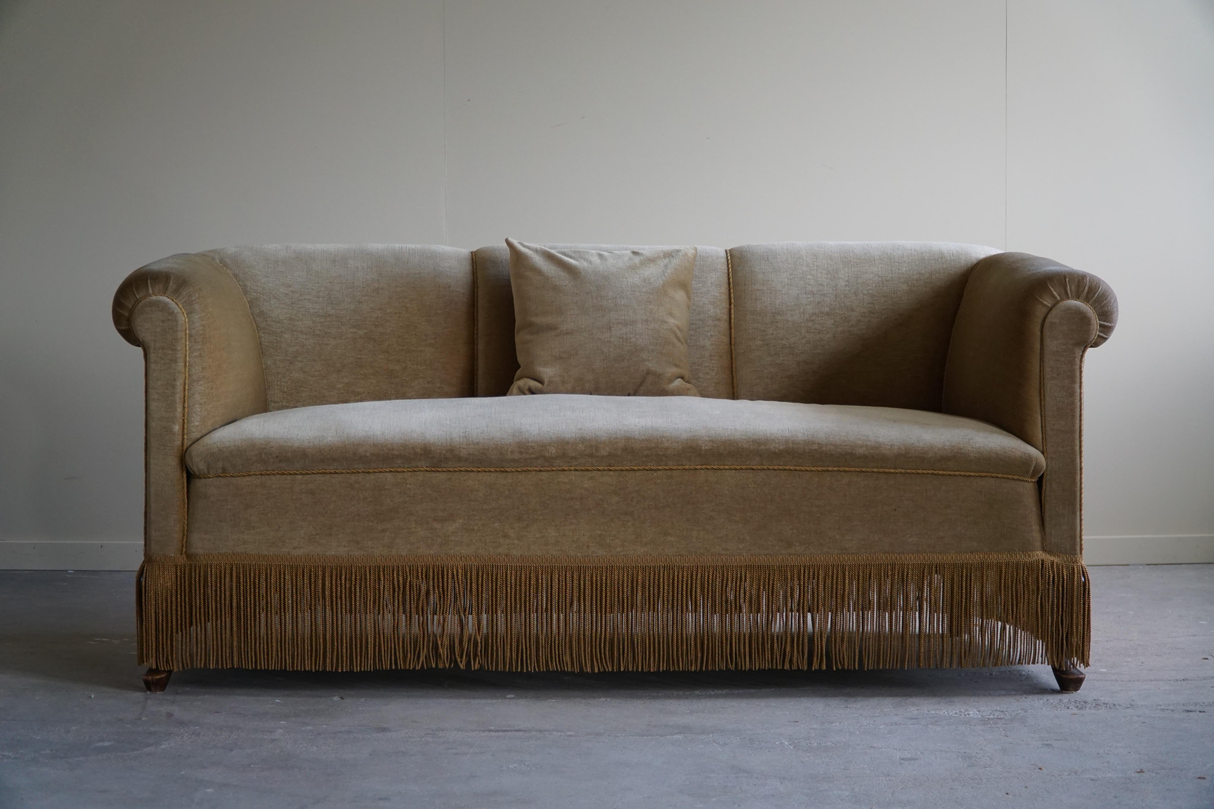 Dieses ansprechende Zweisitzer-Sofa aus grünem Velours zeigt die bemerkenswerte Handwerkskunst eines dänischen Tischlers aus der Zeit des Art déco in den 1940er Jahren. Dieses Sofa strahlt Eleganz und Raffinesse aus, indem es die luxuriöse