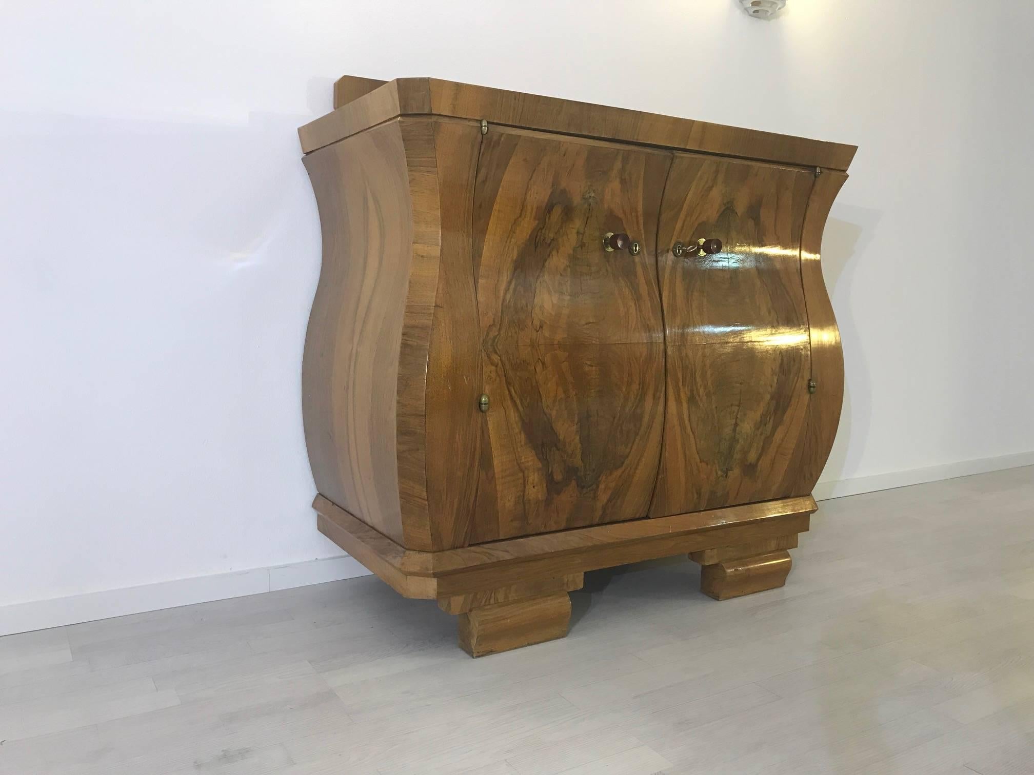 Wonderful Art Deco commode made of luxurious walnut wood with a stunning grain. Beautiful French single piece from the 1920s with an elegant tulip body. Offers great curved doors and an amazing hutch on top.

 French original piece from the Art
